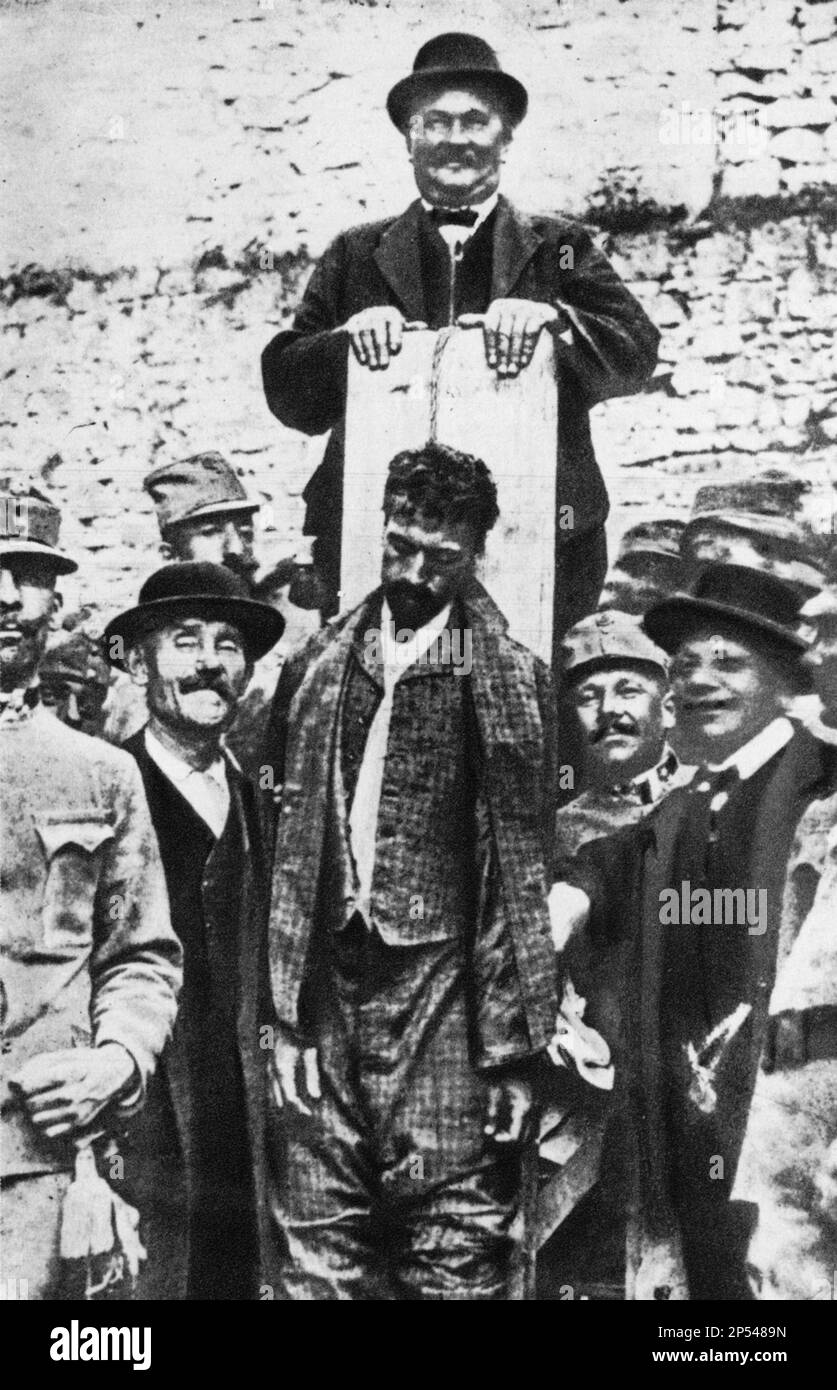 1916 , 12 july , TRENTO , Trentino Alto Adige , ITALY : The italian patriot CESARE BATTISTI ( 1875 - 1916 ) prisoner of austrian soldiers just after the verdict of death sentence hanged at Castello del Bonconsiglio , in this photo the hangman smile   - Italia foto storiche - HISTORY  - WWI - PRIMA GUERRA MONDIALE - World War - Great War - Grande Guerra  - POLITICA - POLITIC - PATRIA - PATRIOTA - EROE - barba - beard - military uniform - uniforme divisa militare - prigioniero - condannato a morte - condanna - impiccato - impiccagione ----  Archivio GBB Stock Photo