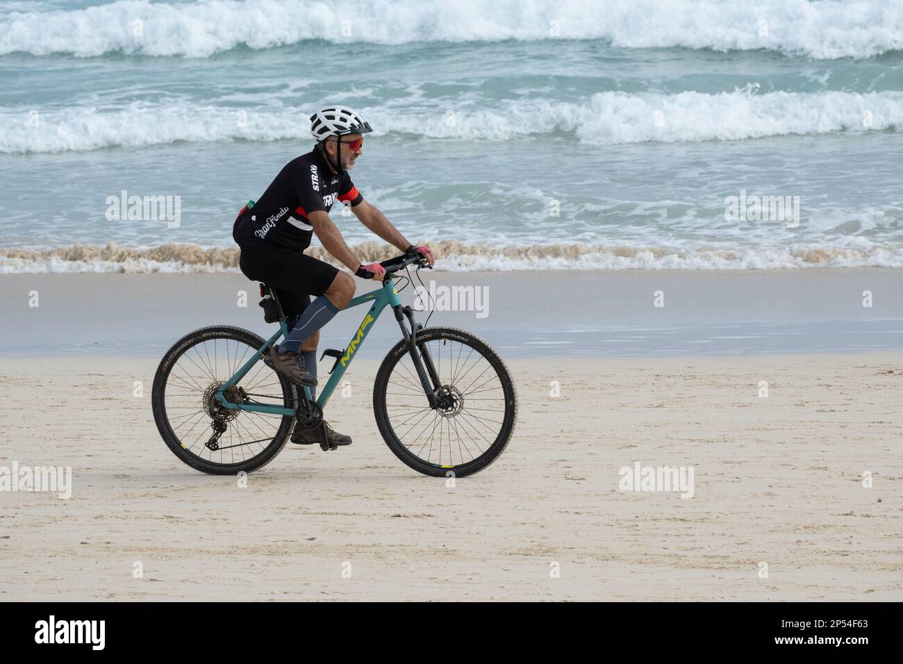Man riding bike, bicycle on beach Stock Photo