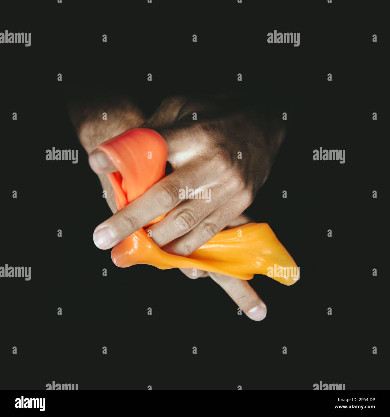 A picture of hands coming out of the dark with a glitchy orange colored slime wrapped around the fingers. Stock Photo