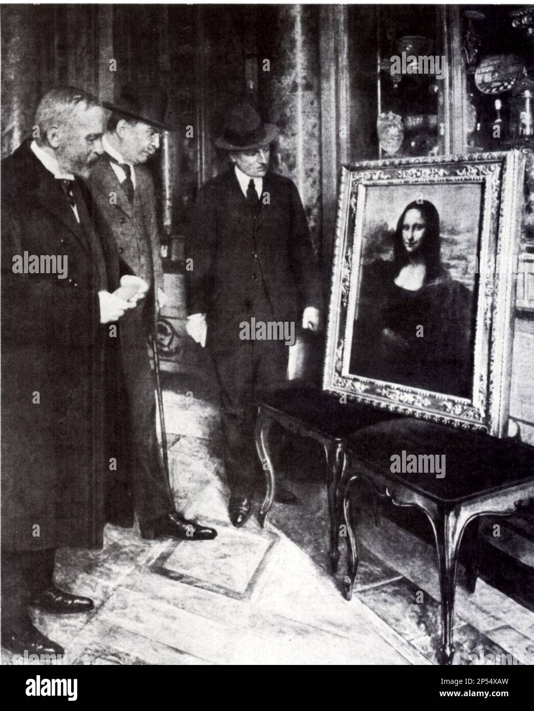 1913 , Firenze , Italy : The celebrated painting  La GIOCONDA by LEONARDO DA VINCI exibited at UFFIZI Galleries after was found in Florence. Robbed the 21 august 1911 from the Louvre in Paris , France , by the italian patriotic housepainter  Vincenzo Perugia ( Peruggia ) . In this photo the painter LUIGI CAVENAGHI ( 1844 - 1918 , restorer in Milano of Cenacolo by Leonardo in Santa Maria delle Grazie ), CORRADO RICCI ( director of italian Belle Arti office ) and the professor Doctor GIOVANNI  POGGI ( director of Uffizi Gallery ) - FURTO - foto storiche - history - ladro - thief - museo ----  Ar Stock Photo