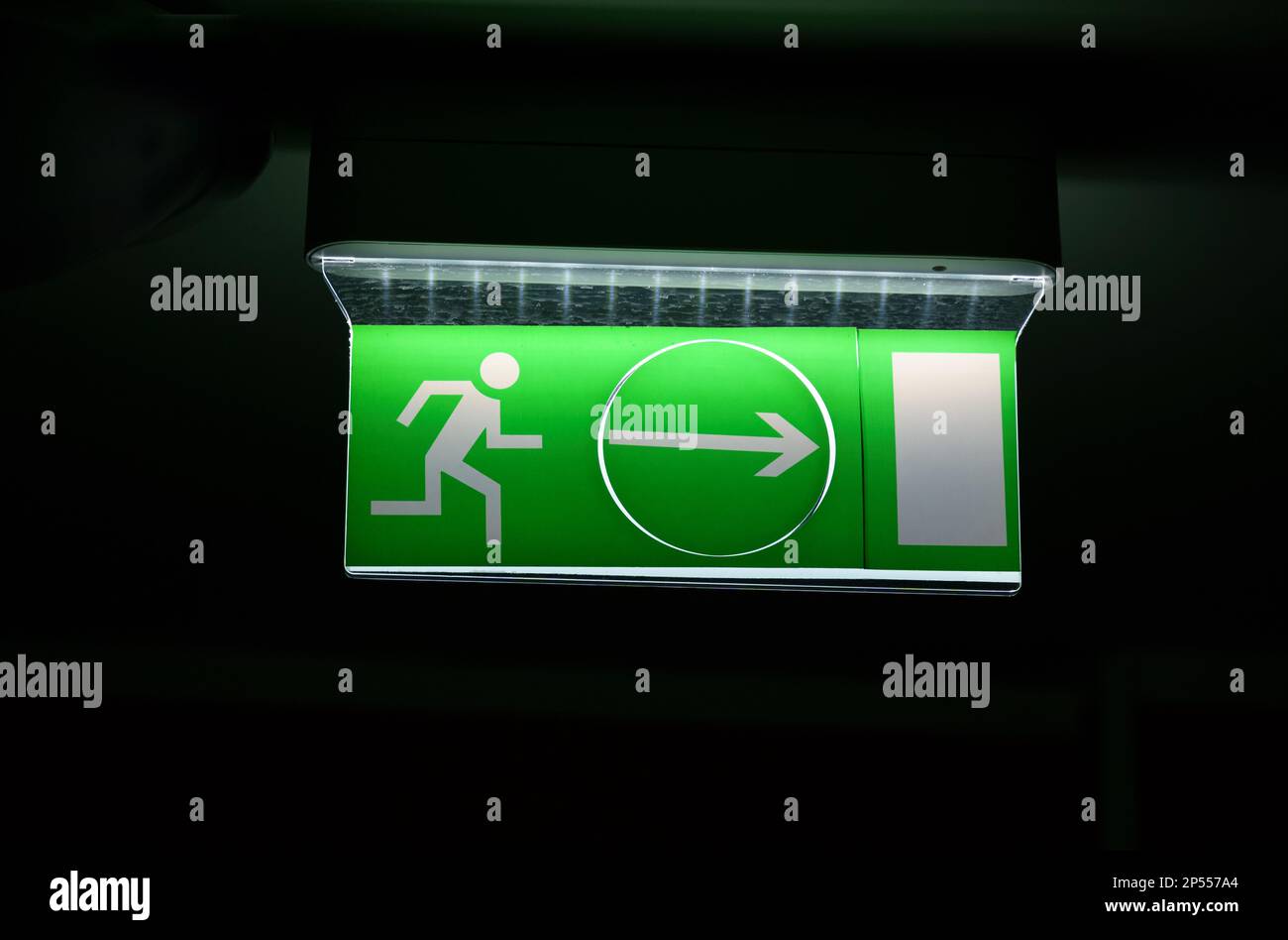 A green warning light board depicting a running man with an arrow