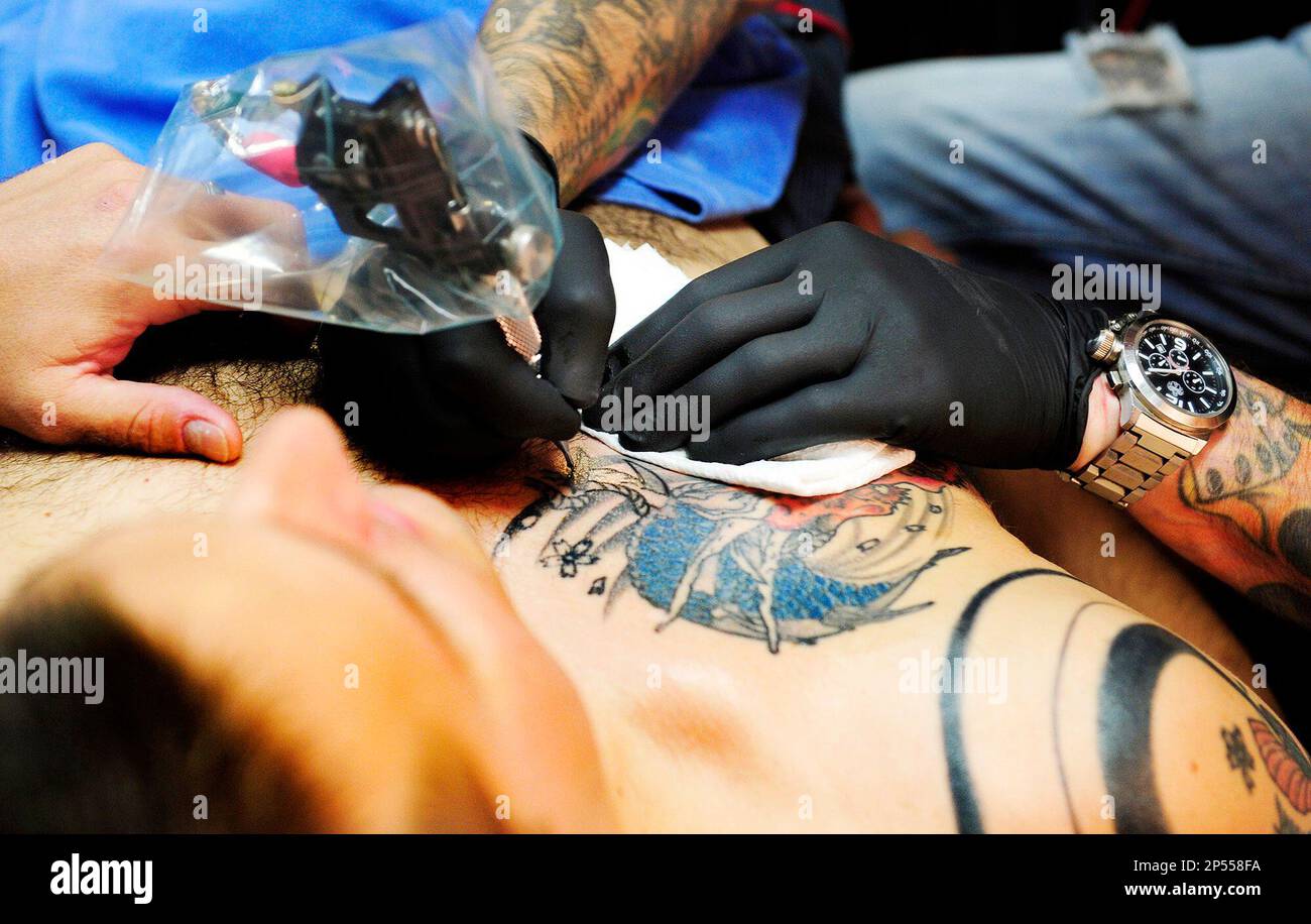 In this Aug 29 2013 photo Artist Kenny McGee works on a dragon tattoo  for client Dan Dorsey at Aces and Eights Tattoo  Piercing in Augusta Ga  Health officials say tattoo