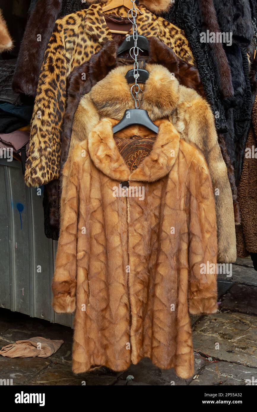 Warm retro style winter coats made from real fur hanging on a market Stock Photo