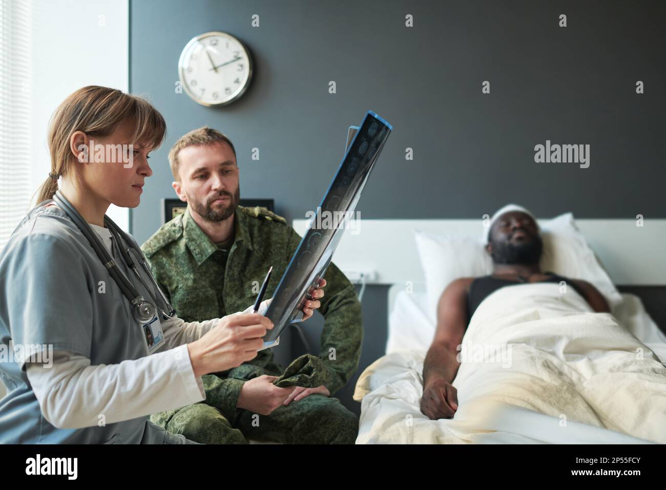 Young nurse or radiologist showing soldier in military uniform result