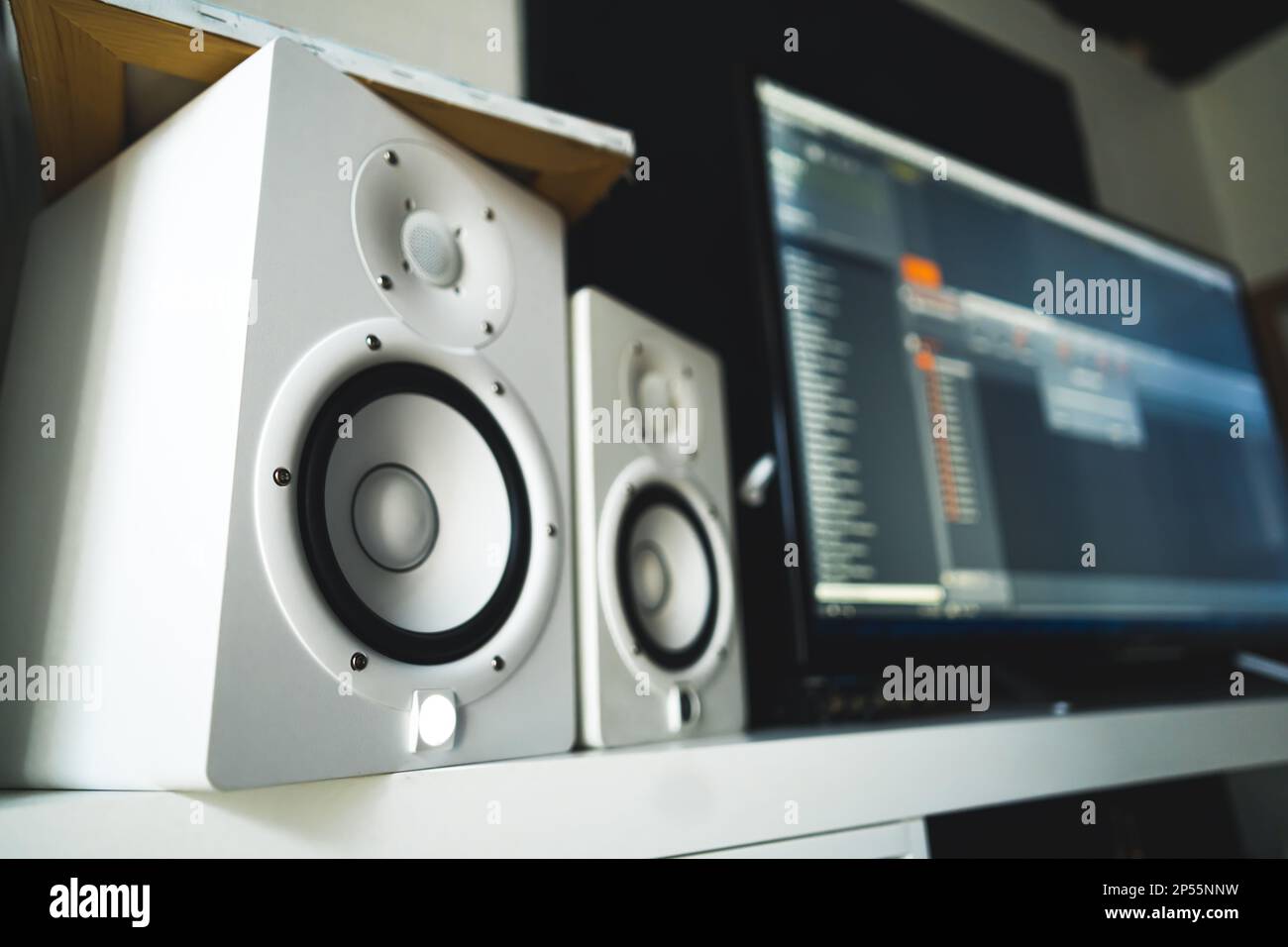 closeup shot of the white speakers, MIDI sequencer in the background, recording studio. High quality photo Stock Photo