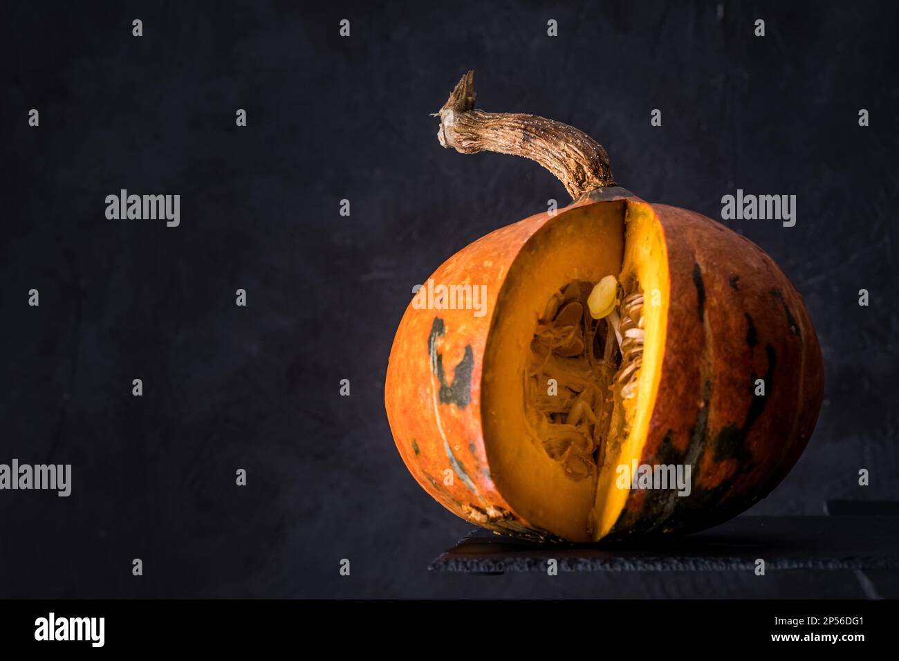 Close-up of an orange pumpkin isolated on dark slate background. copy space for text Stock Photo