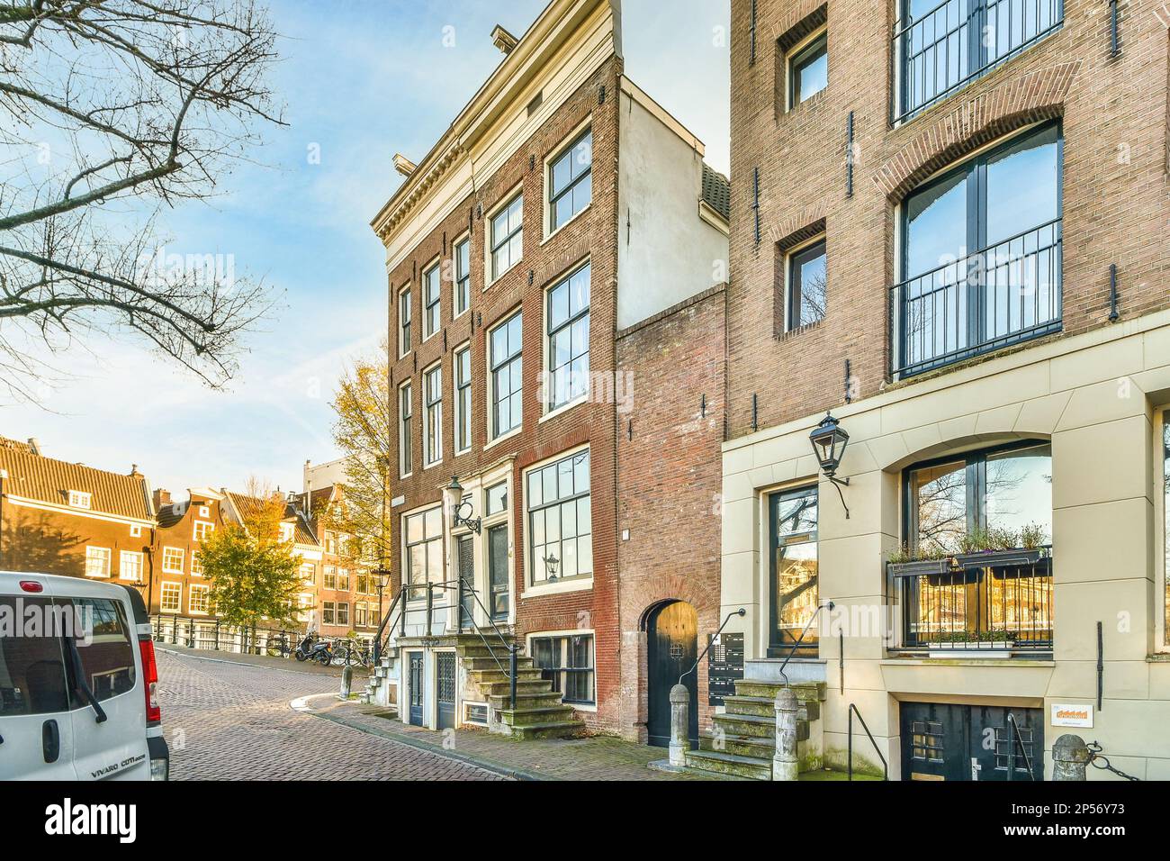 a city street with parked cars on the side and buildings in the back ...