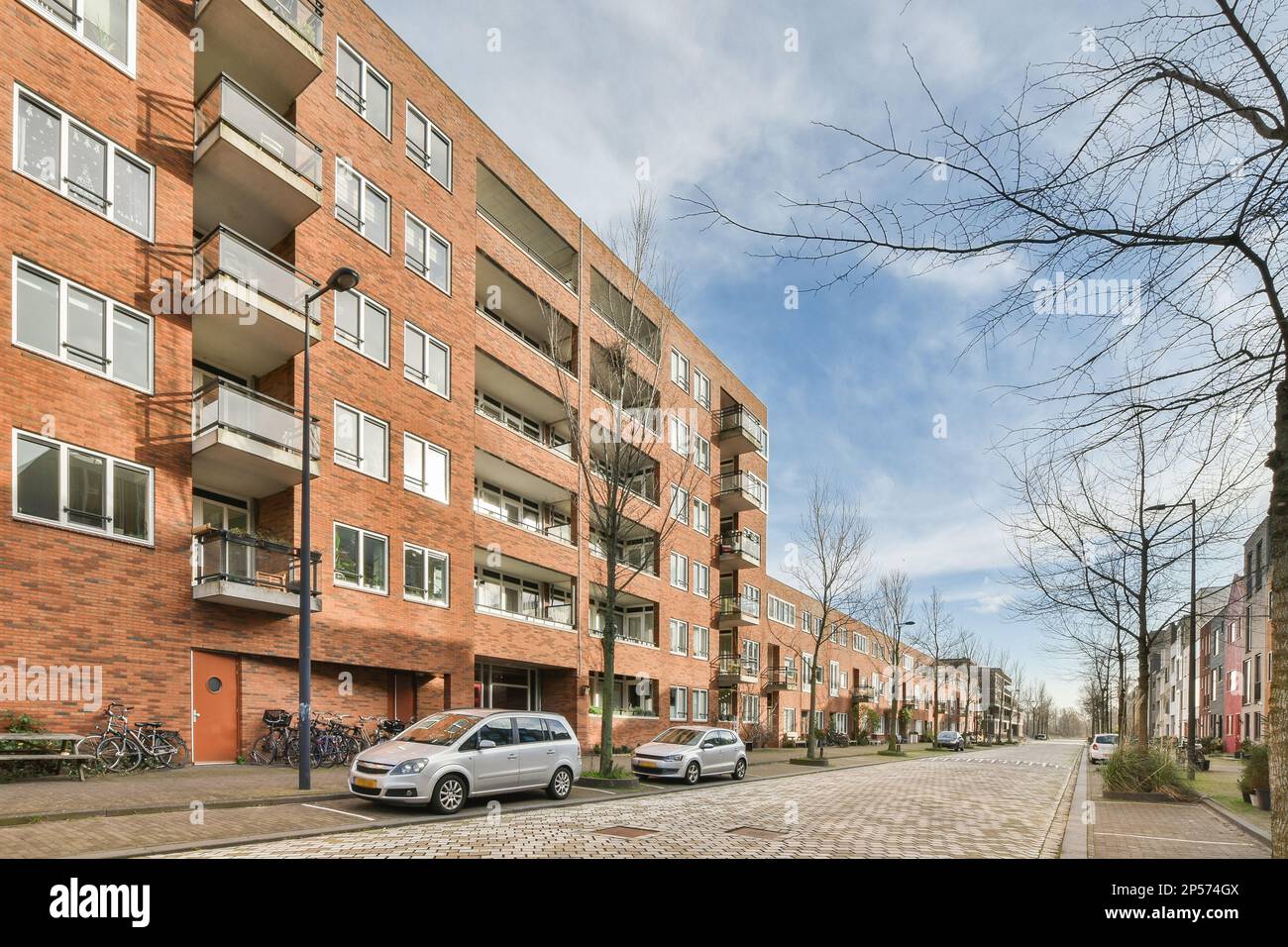 a city street with cars parked on the side and apartment buildings in ...