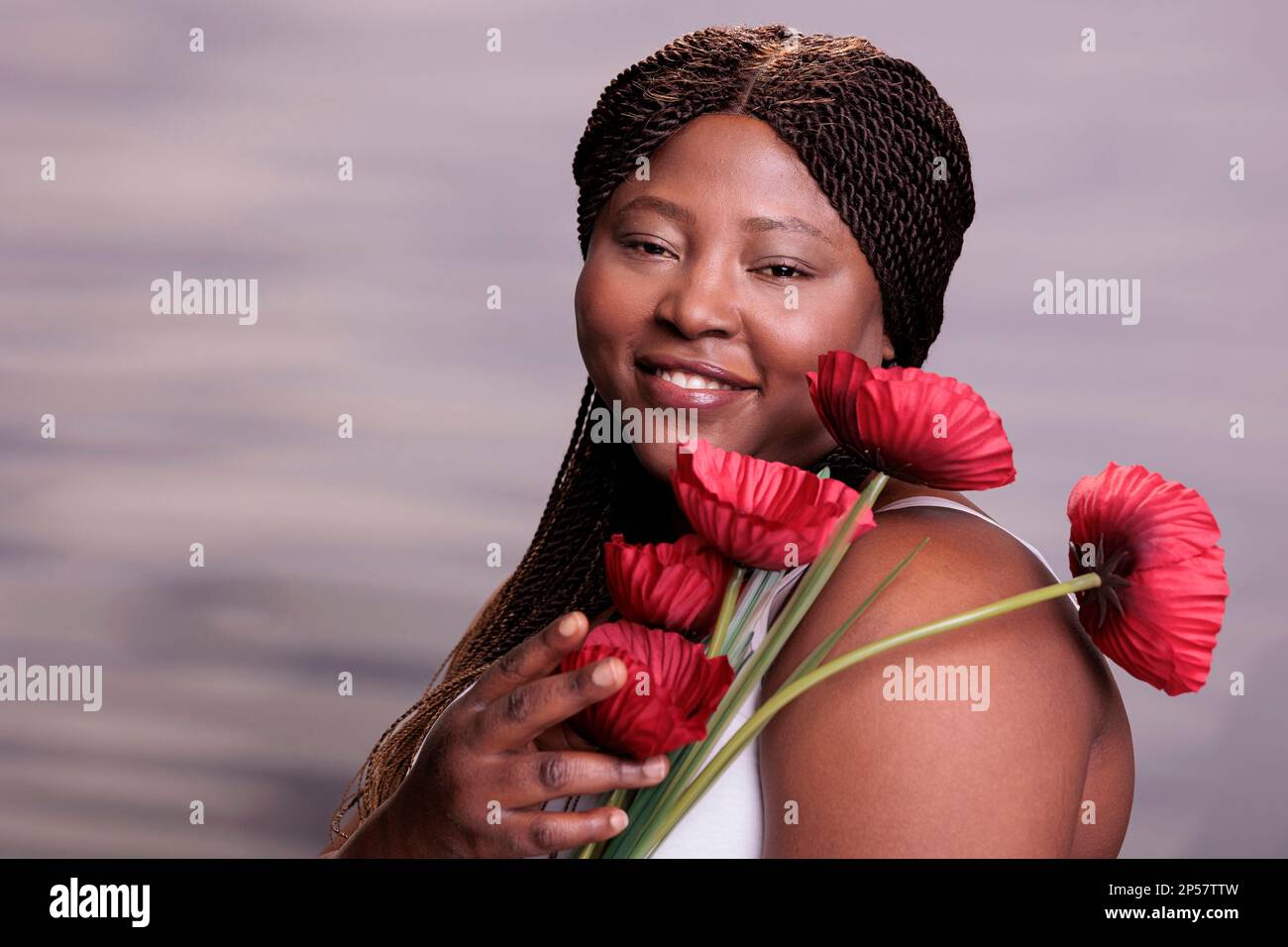 African american woman holding poppy flowers portrait, showing