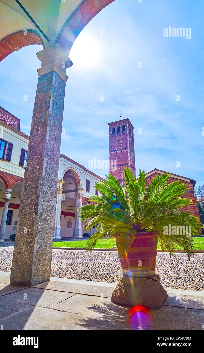 The view on the courtyard of Basilica of Sant'Ambrogio and the bell tower through the arcades of its church, Milan, Italy Stock Photo