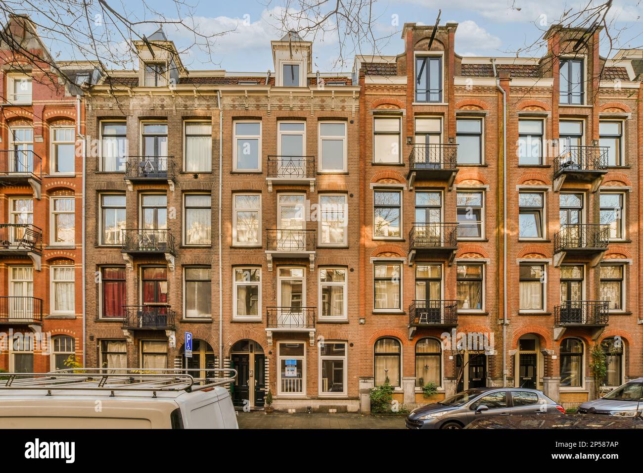 an apartment building with cars parked on the street in front of it and ...