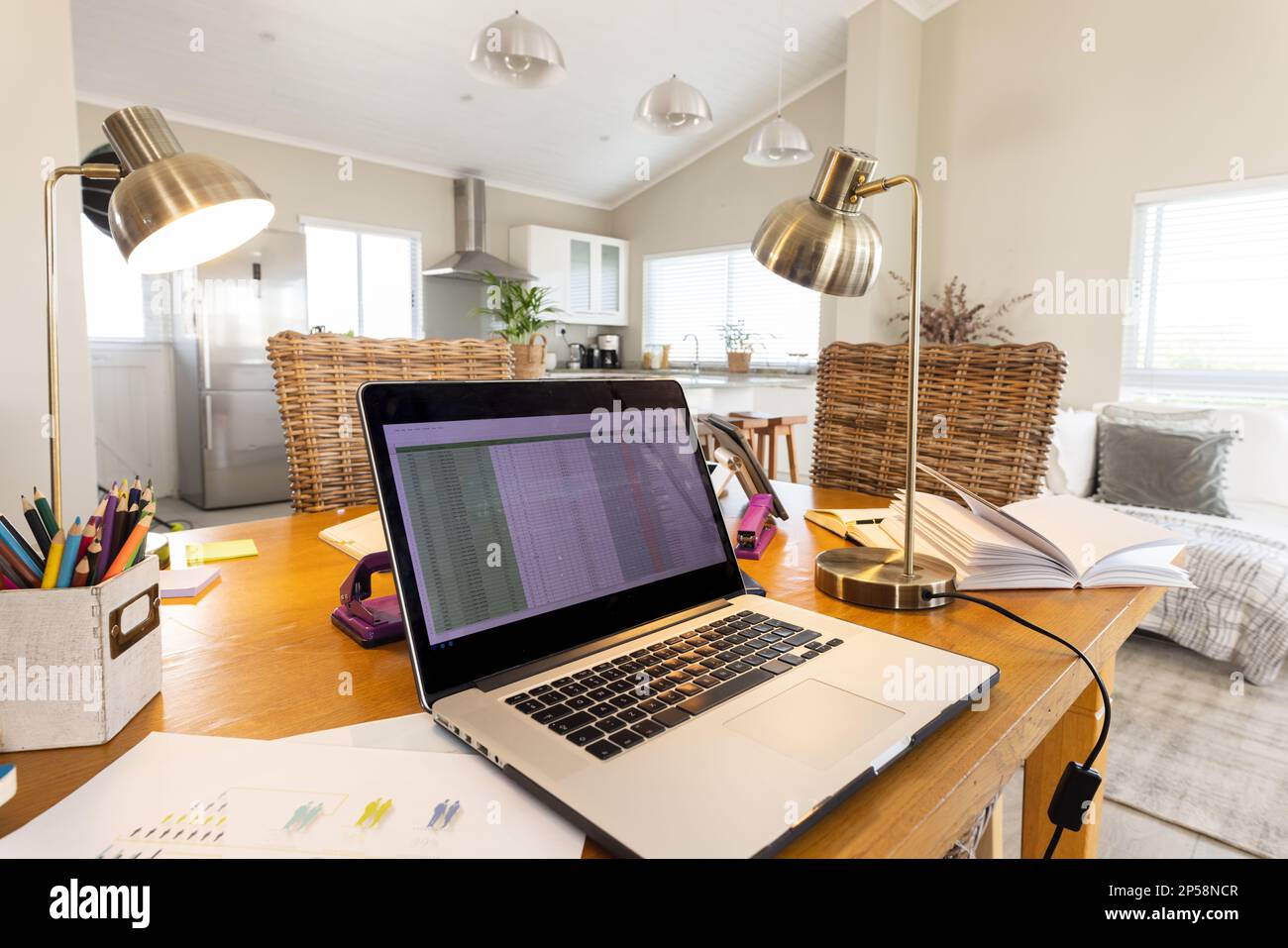 Close up of laptop and documents on table in cosy living room Stock Photo