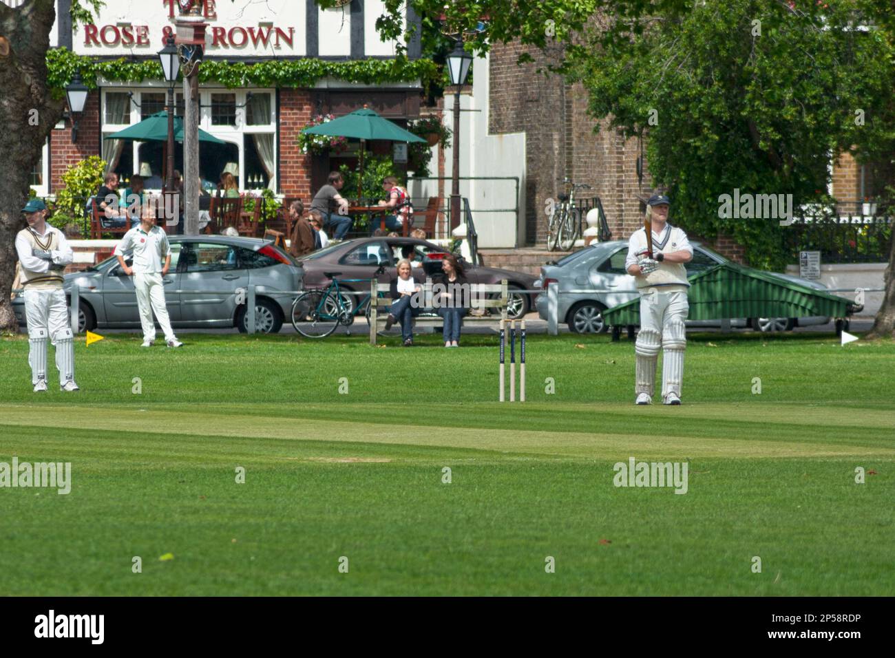 Kew, England - May 19 2007: Friendly match of cricket on Saturday morning on the field opposite of the pub “The Rose & Crown” in Kew, near London. Stock Photo