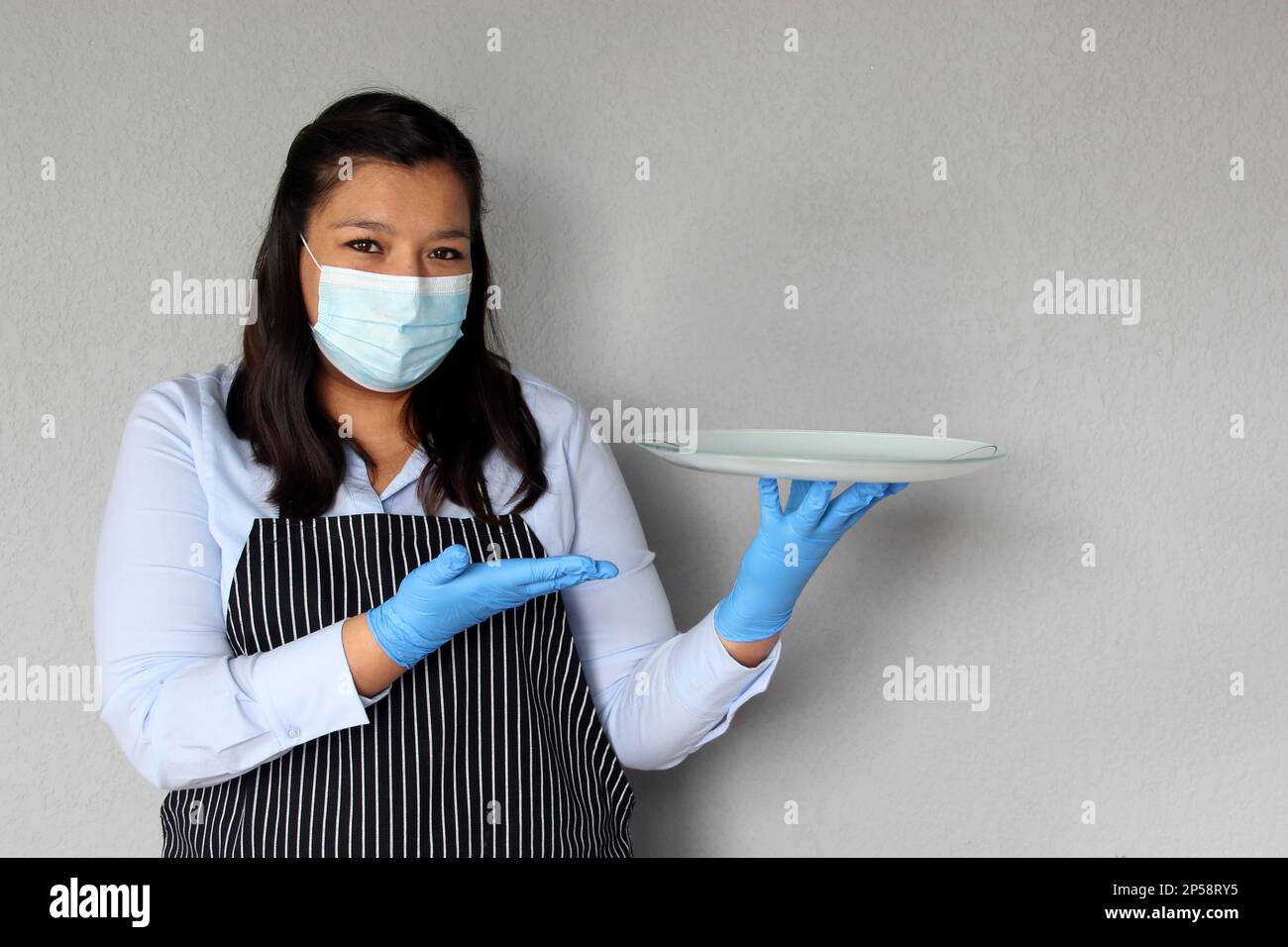 Latina waitress woman with protection mask and latex gloves working