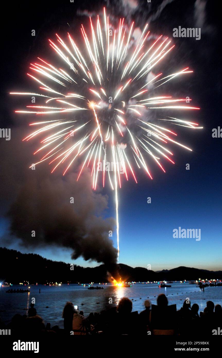Black smoke billows from the pyrotechnics barge on Whitefish Lake after catching fire toward the
