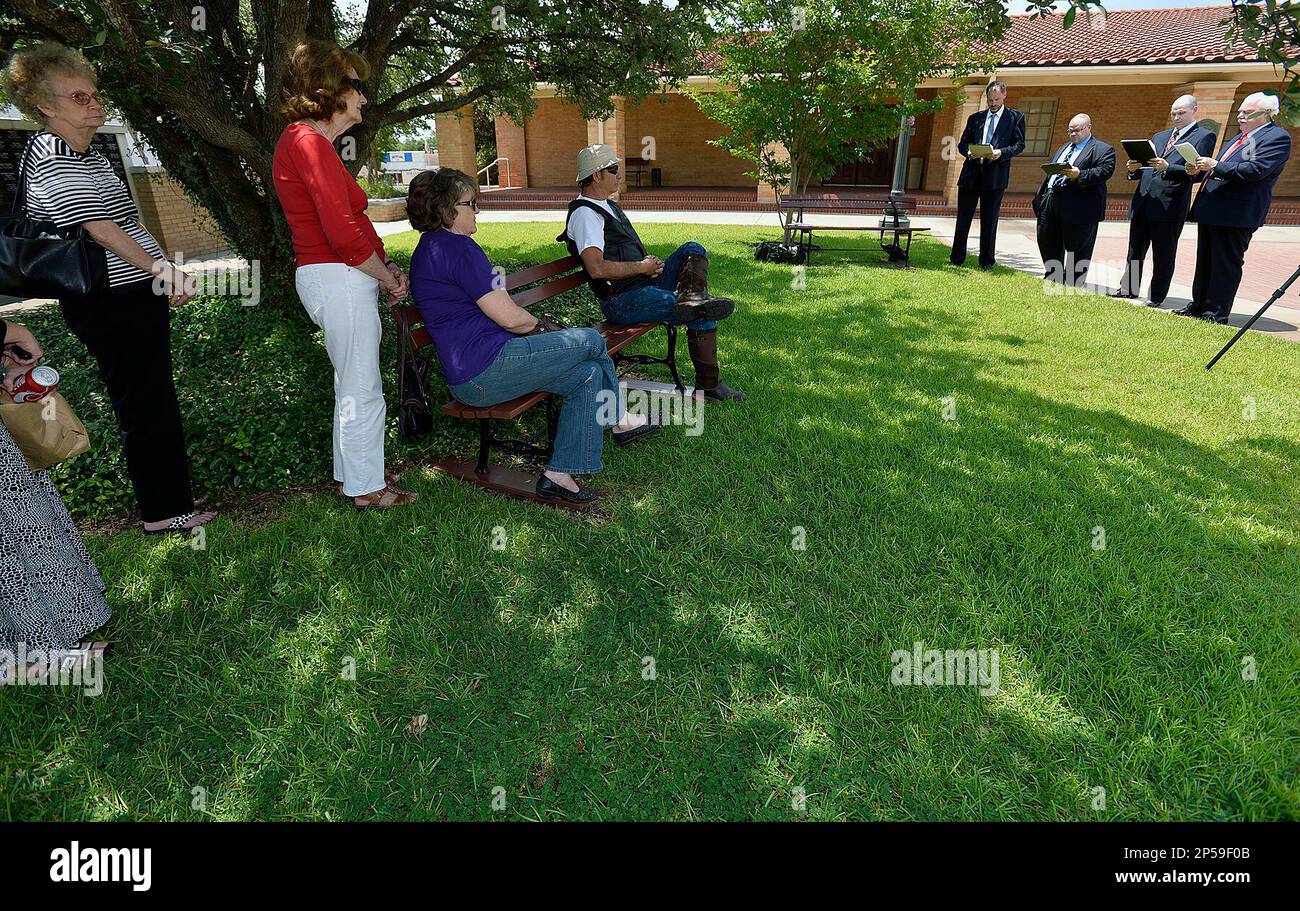 A small group of onlookers listen Wednesday, July 3, 2013, as local