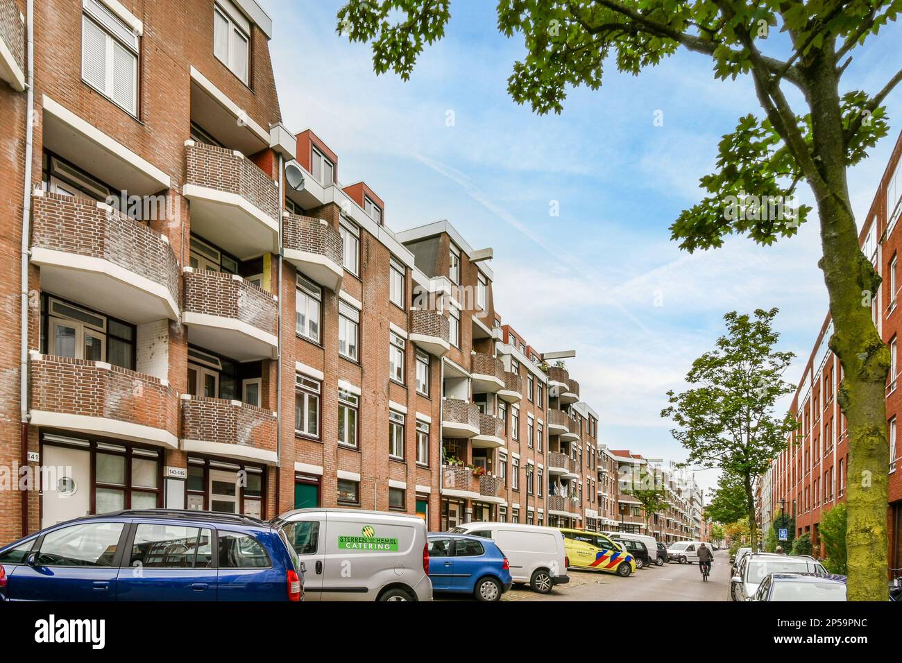 a street with cars parked on the side and people walking down the ...