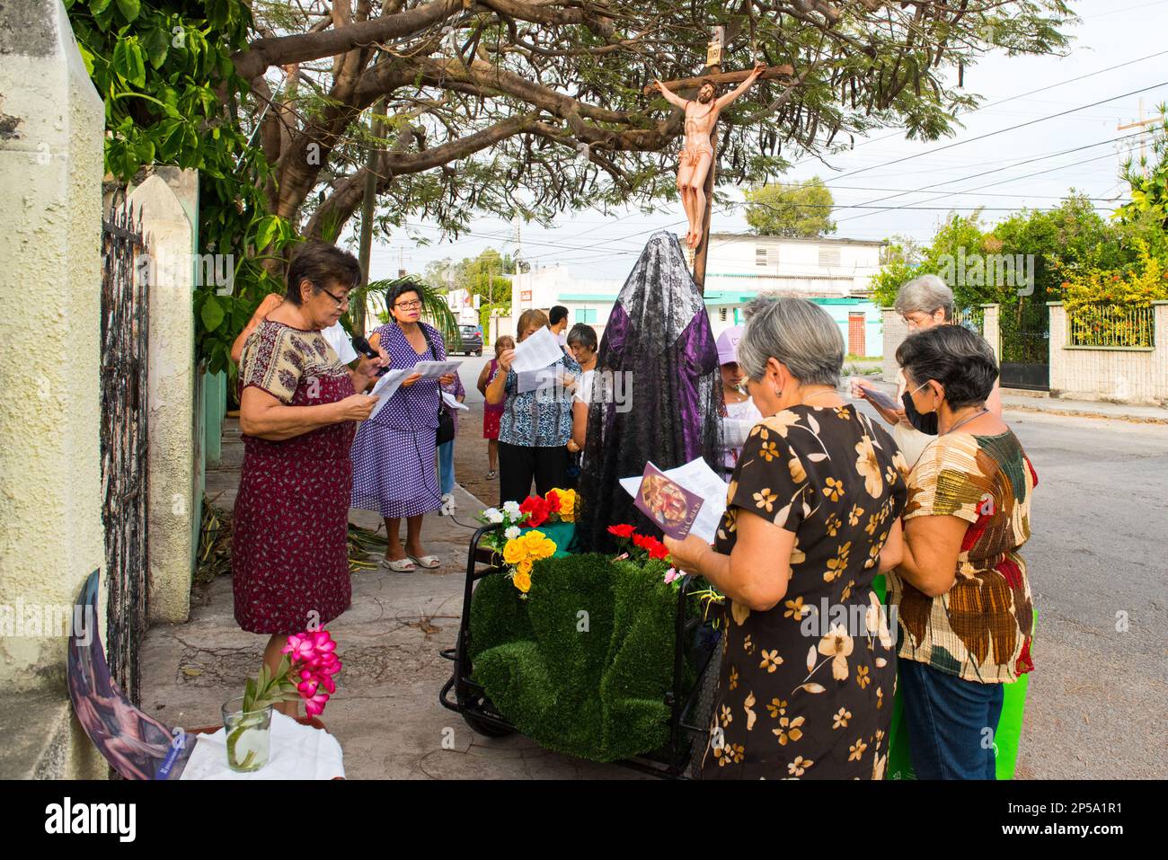 To mark the seventh friday of Lent, small homme altars are set up in some of the more traditional neighborhoods of Merida, Mexico. They are here to  commemorate the suffering of the Virgin Mary. Parishioners go from house to house with a statue of the Virgin Mary and a cross with Jesus, they pray and sing religious cantics for the occasion Stock Photo