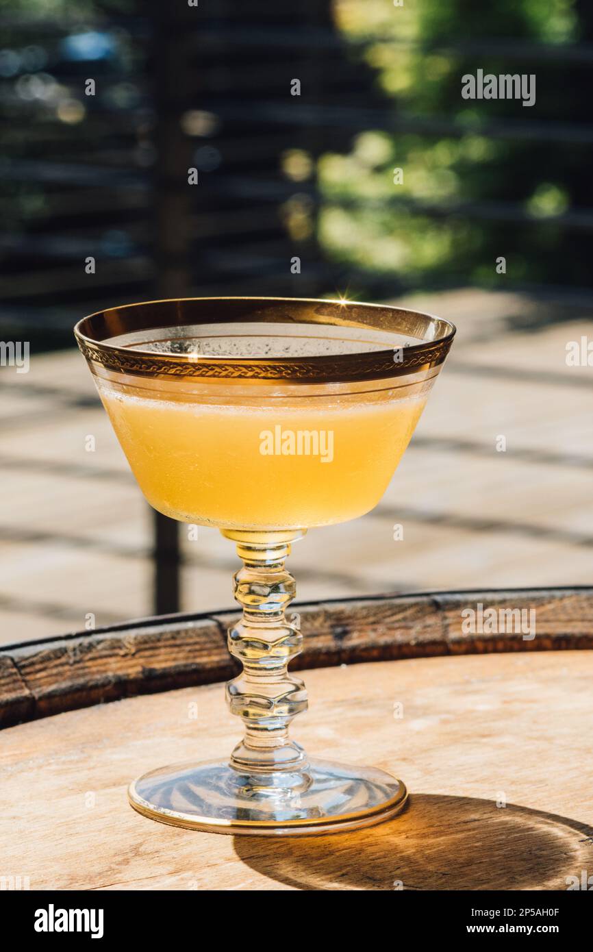 yellow whiskey cocktail in vintage hotel champagne coupe with gold rim