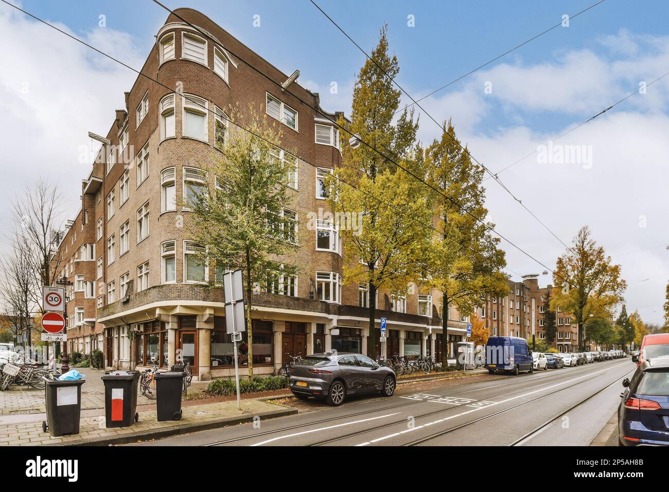 a city street with cars parked on the side of the road and buildings in ...