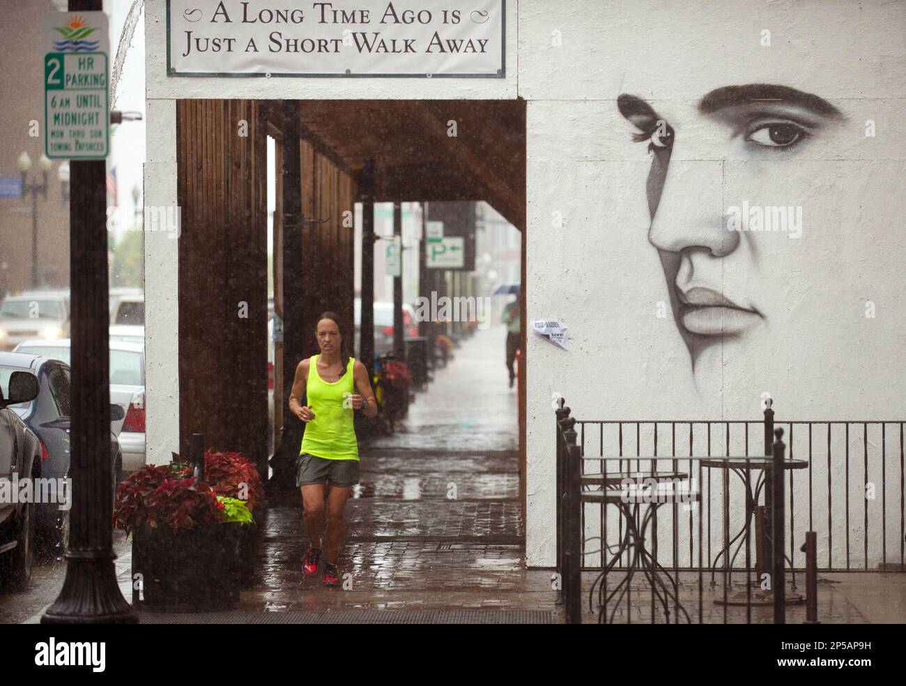 Amy Jones jogs past a rendering of Elvis Presley during a twelve-mile run  on Tuesday, June 18, 2013, in Knoxville, Tenn. The high school cross  country coach wasn't discouraged by a steady