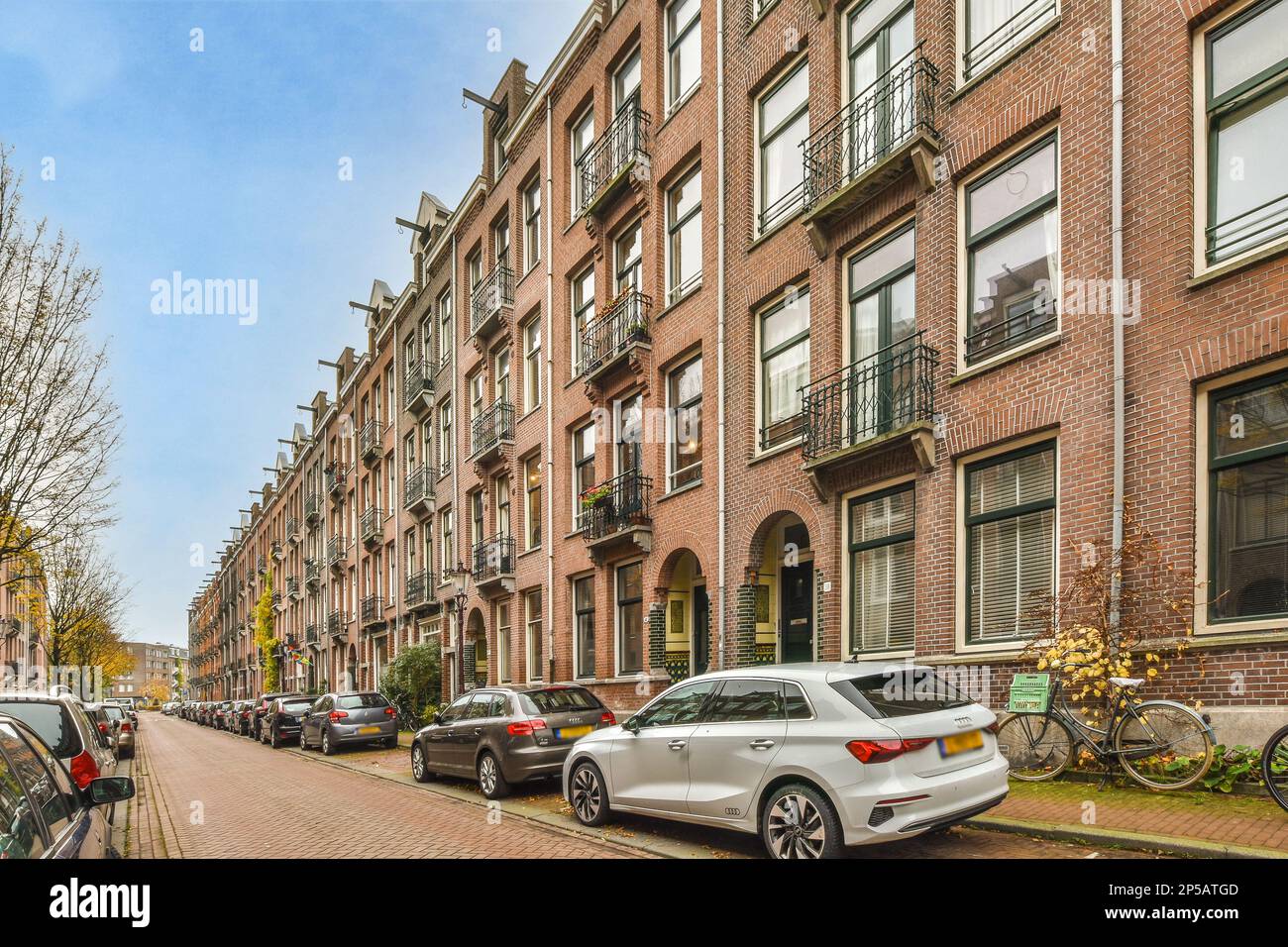 some cars parked on the side of a street in front of a row of brick ...