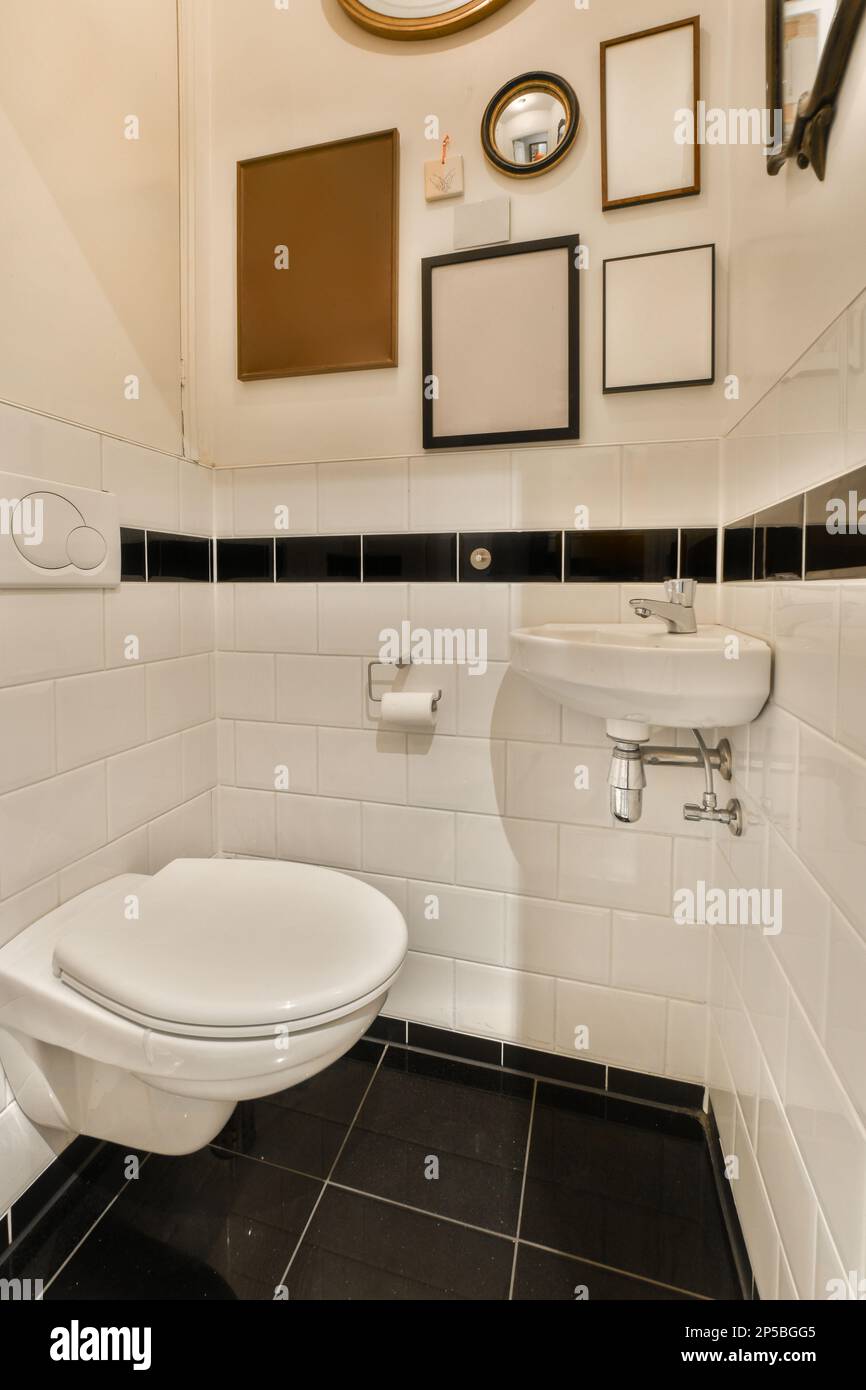 a bathroom with black and white tiles on the floor, mirror above the