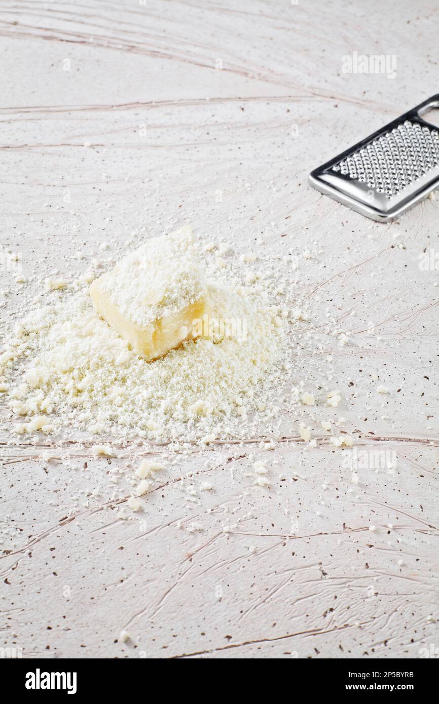 Slice of Parmigiano Reggiano, an Italian grated cheese on a marble base