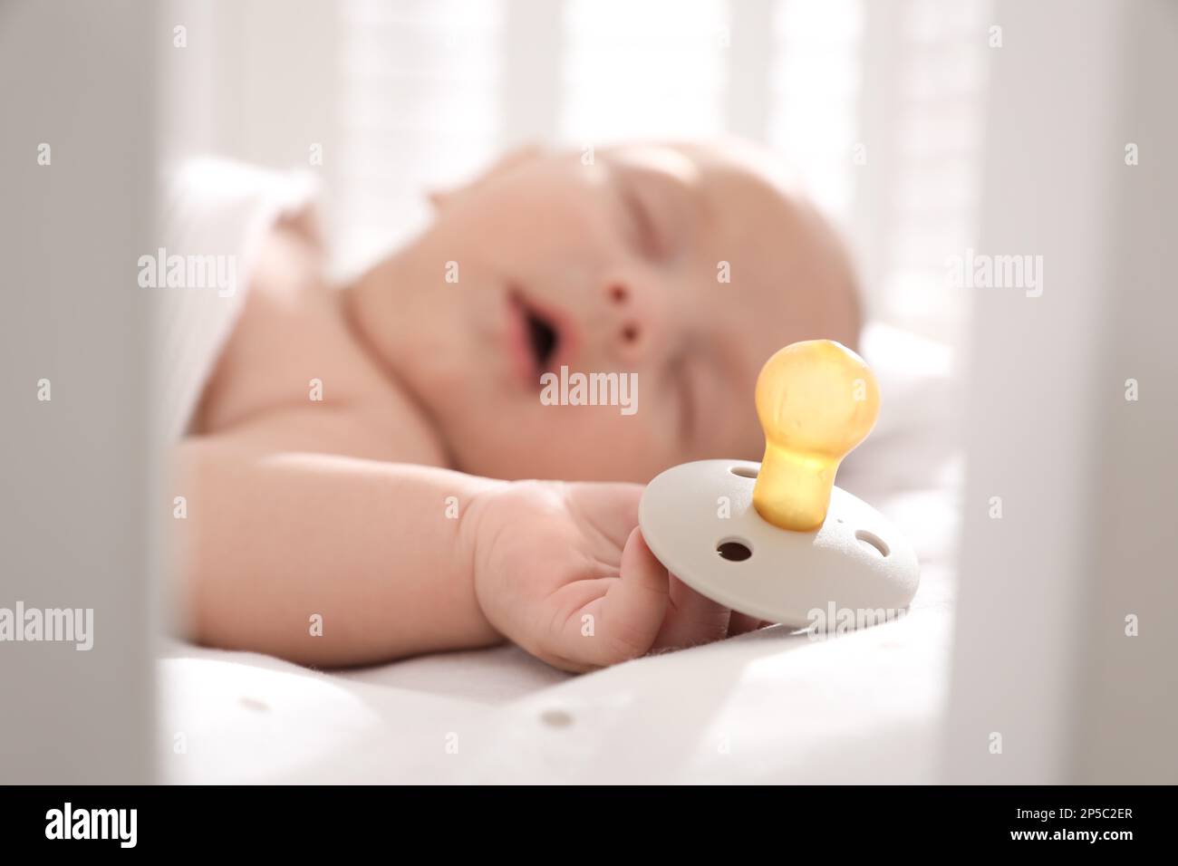 Baby holding a pacifier during a feeding session