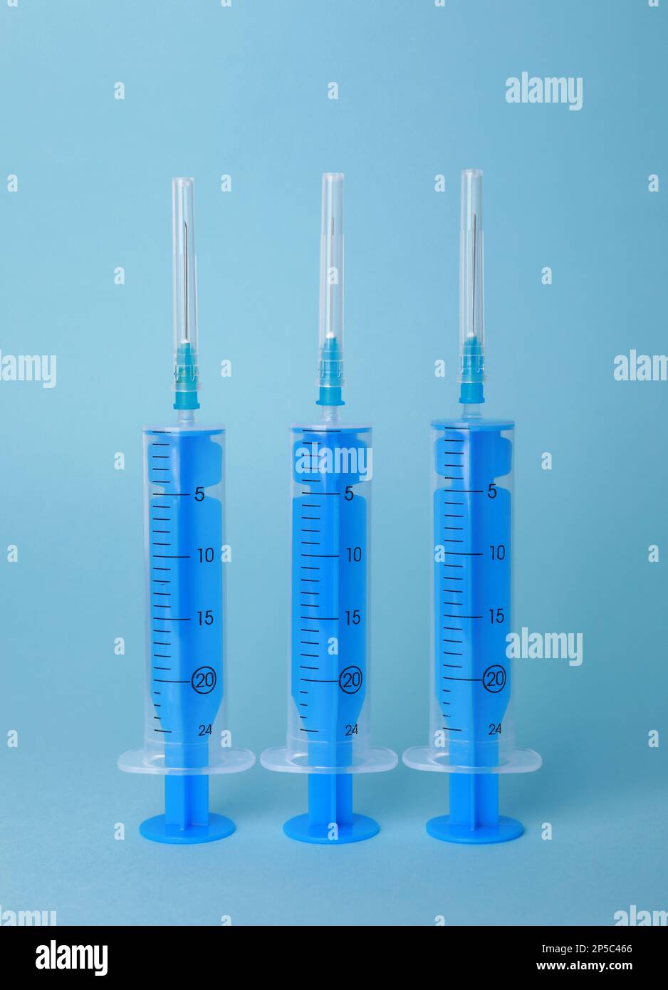 Disposable syringes with needles on light blue background Stock Photo