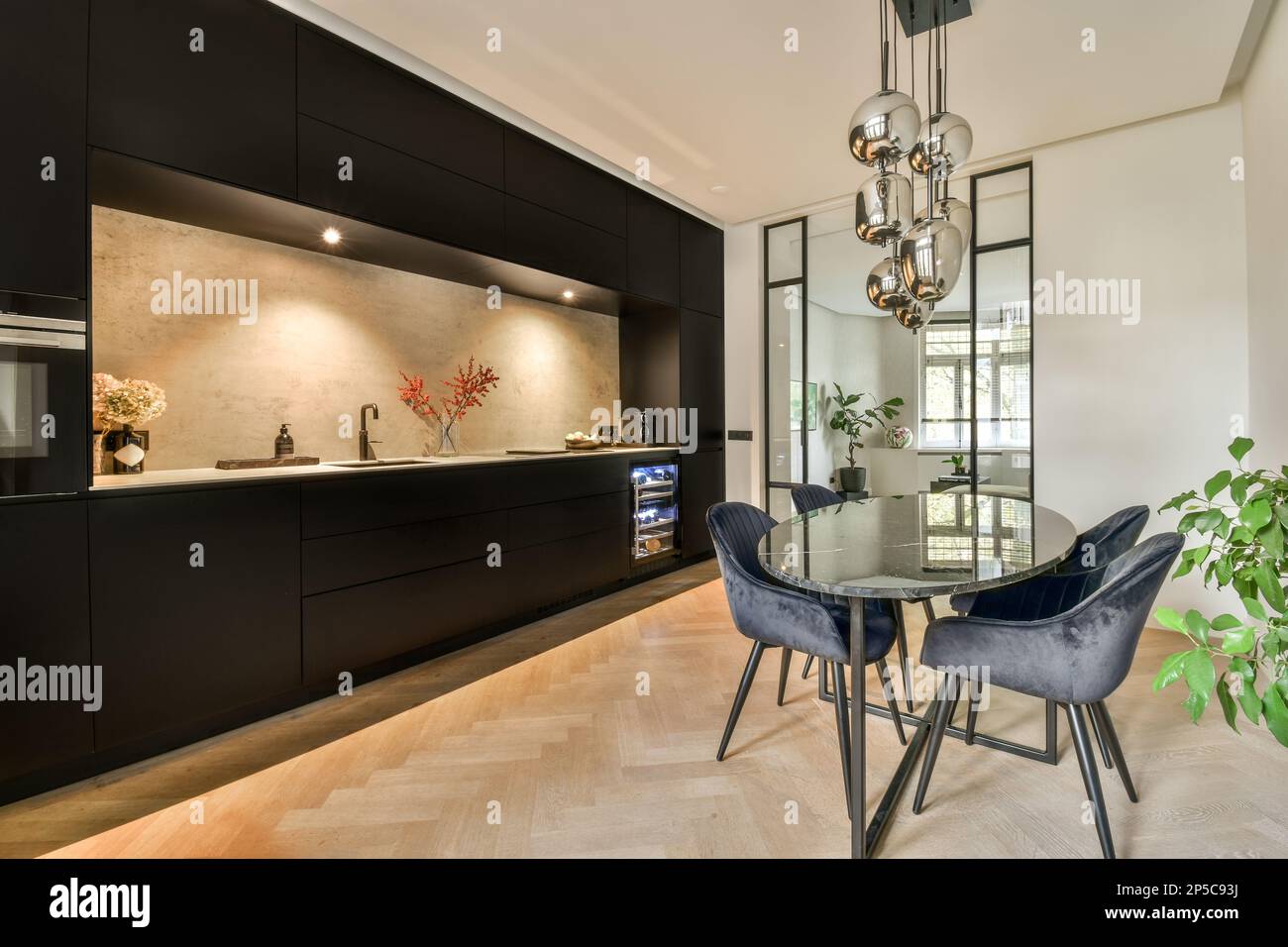 a kitchen and dining area in a modern home with black cabinets, marble ...