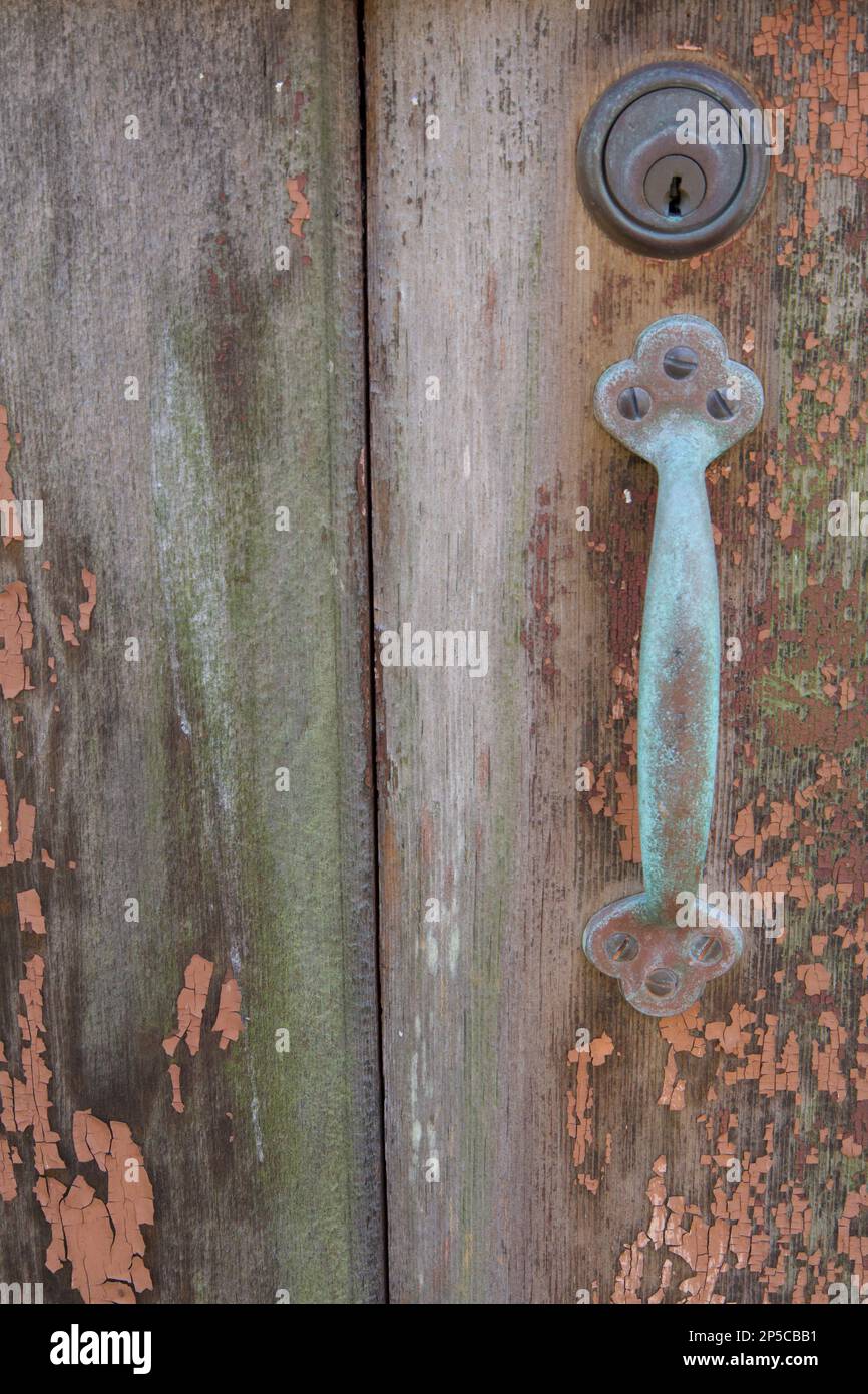 Wooden door with oldfashioned metallic handle and keyhole above the