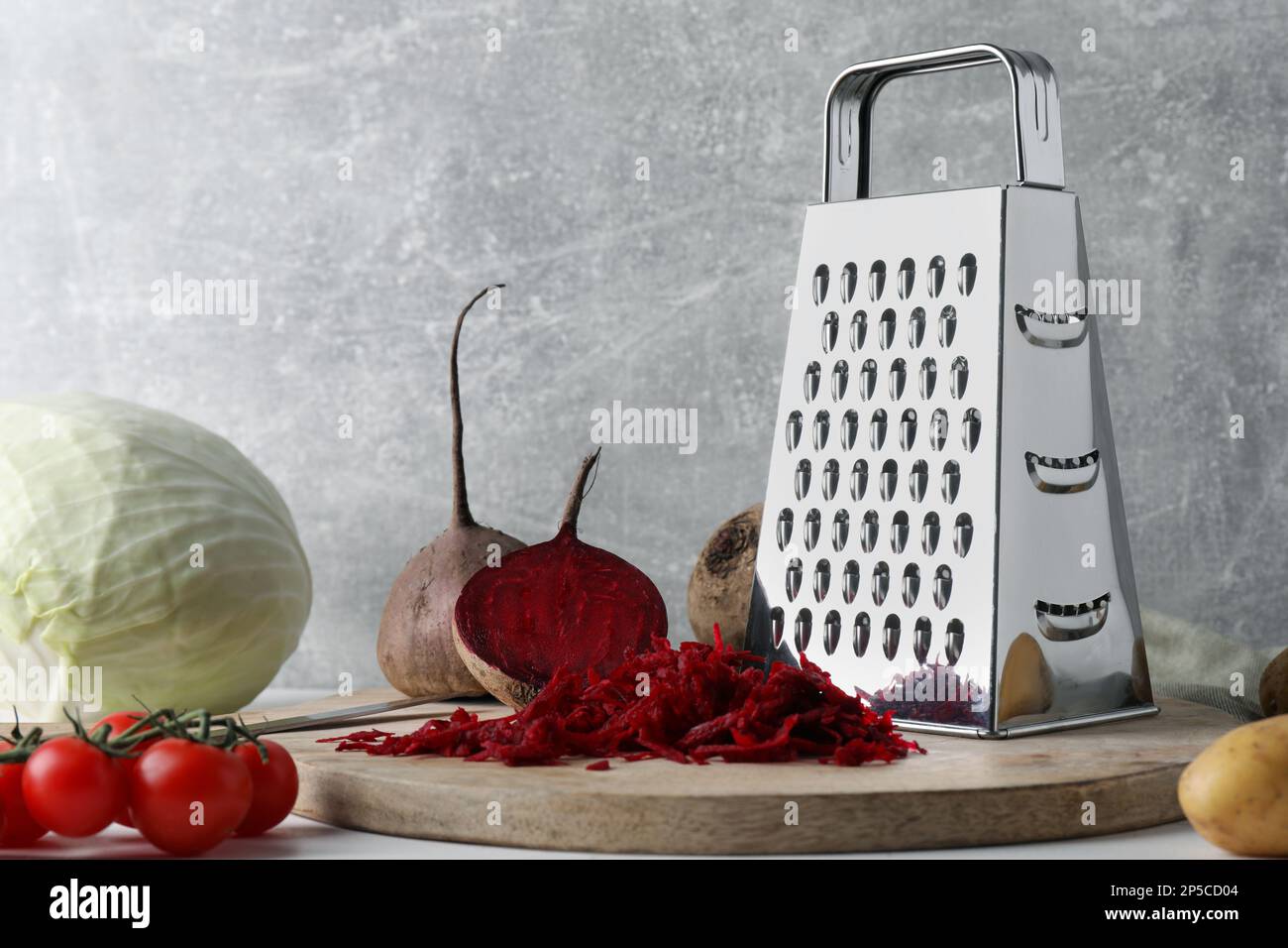 Grater and fresh ripe vegetables on table Stock Photo