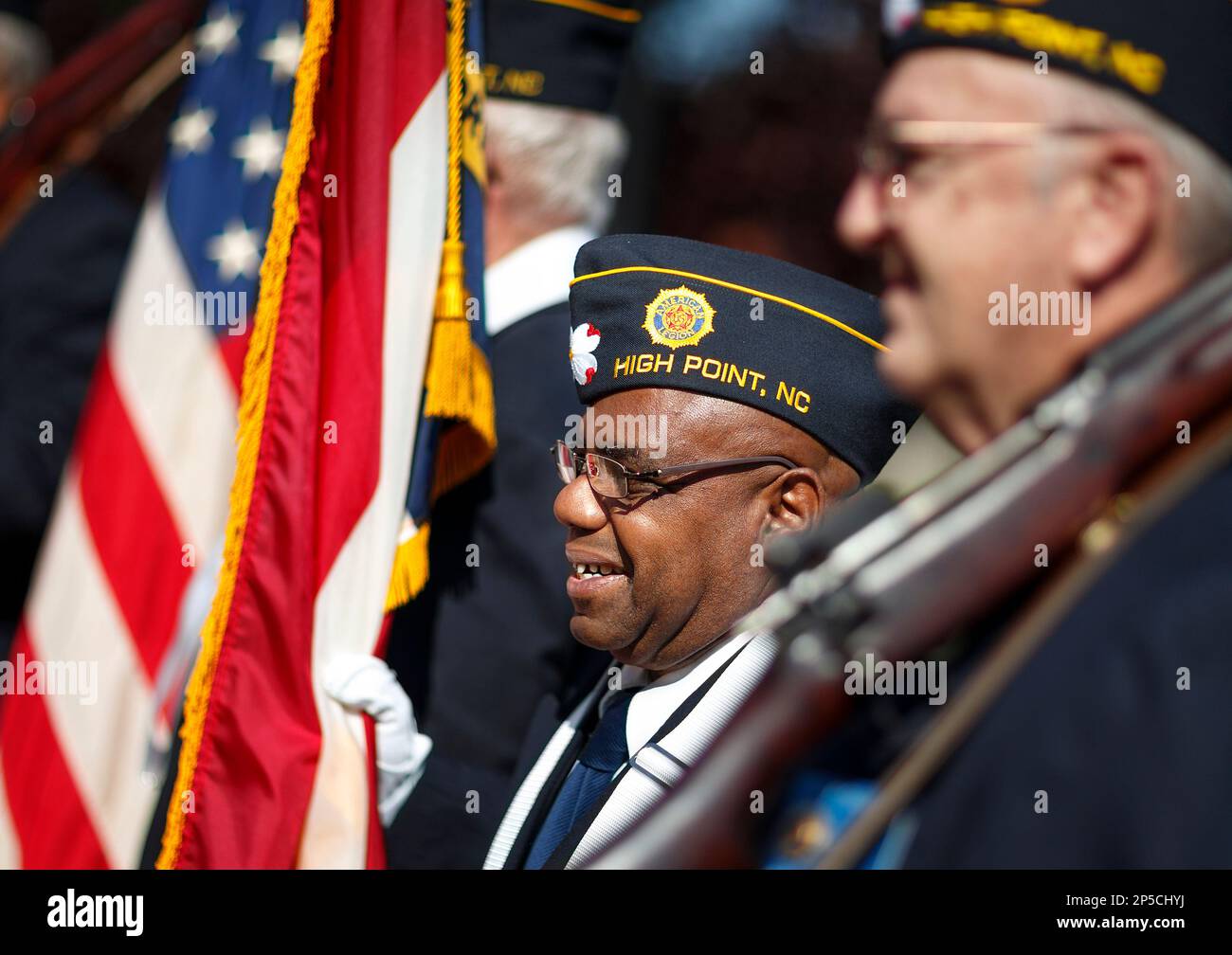 Paul Bogan smiles while holding the North Carolina State Flag as part of  the honor guard from the High Point American Legion Post 87. The High Point  Veterans 10th Anniversary Memorial Service