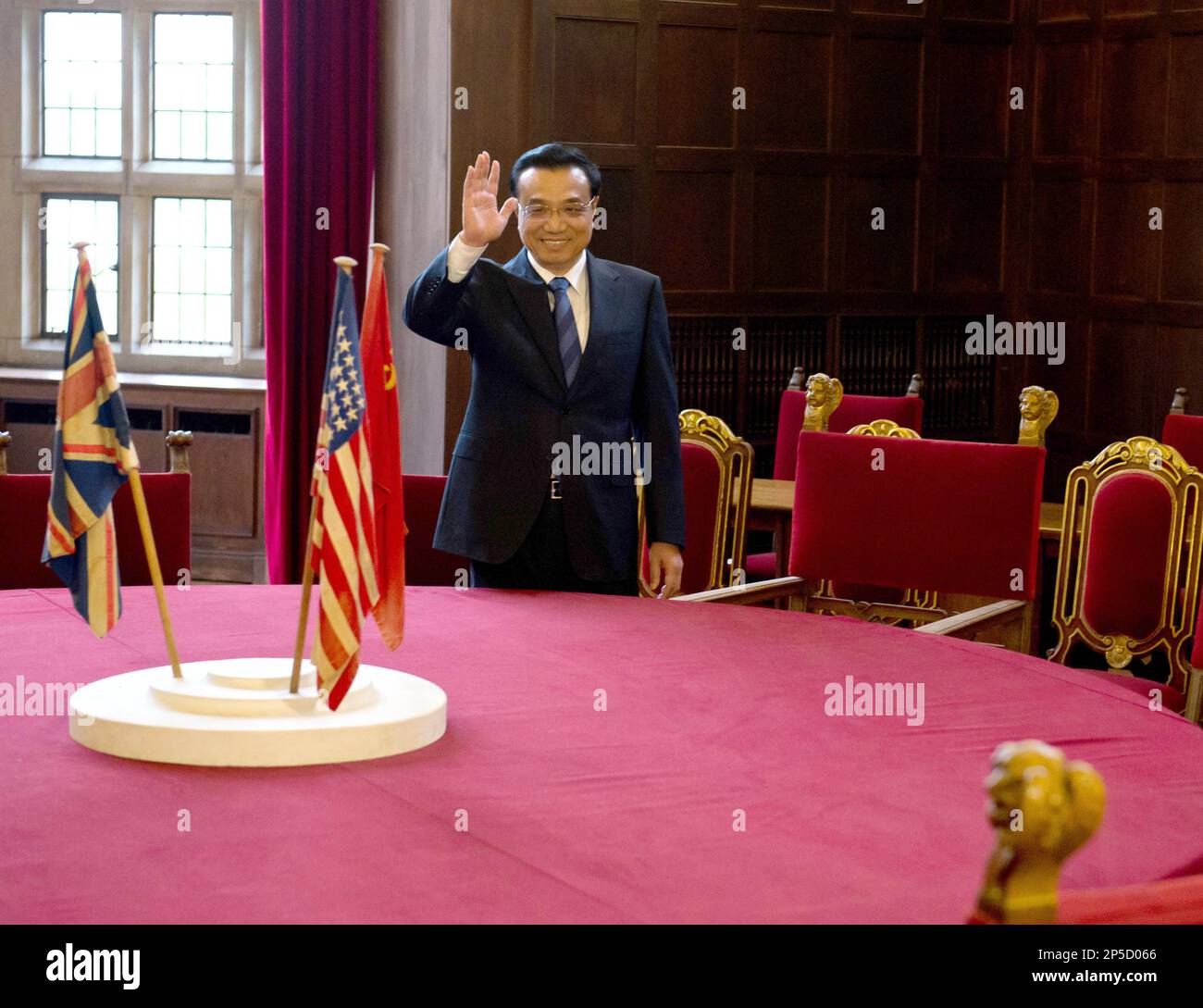 Chinese Prime Minister Li Keqiang, waves as he stands behind the conference table of the 'Potsdam Conference' during his visit at Cecilienhof Castle where, after WWII in 1945, the Potsdam Conference of the Allies took place, in Potsdam, Germany Sunday May 26. 2013. (AP Photo/ Soeren Stache, Pool) Stock Photo