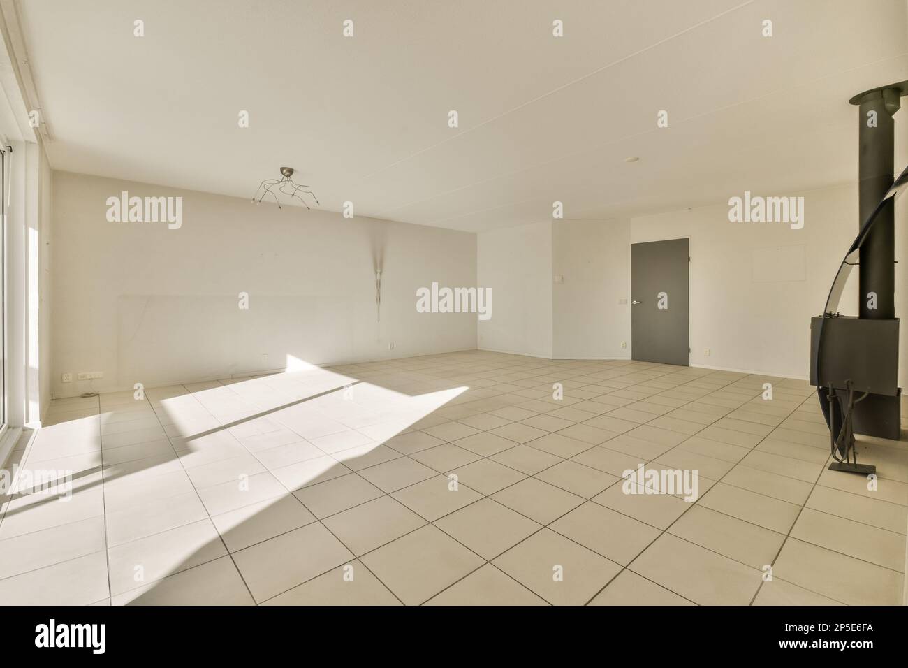 an empty room with white tile flooring and light coming in through the ...
