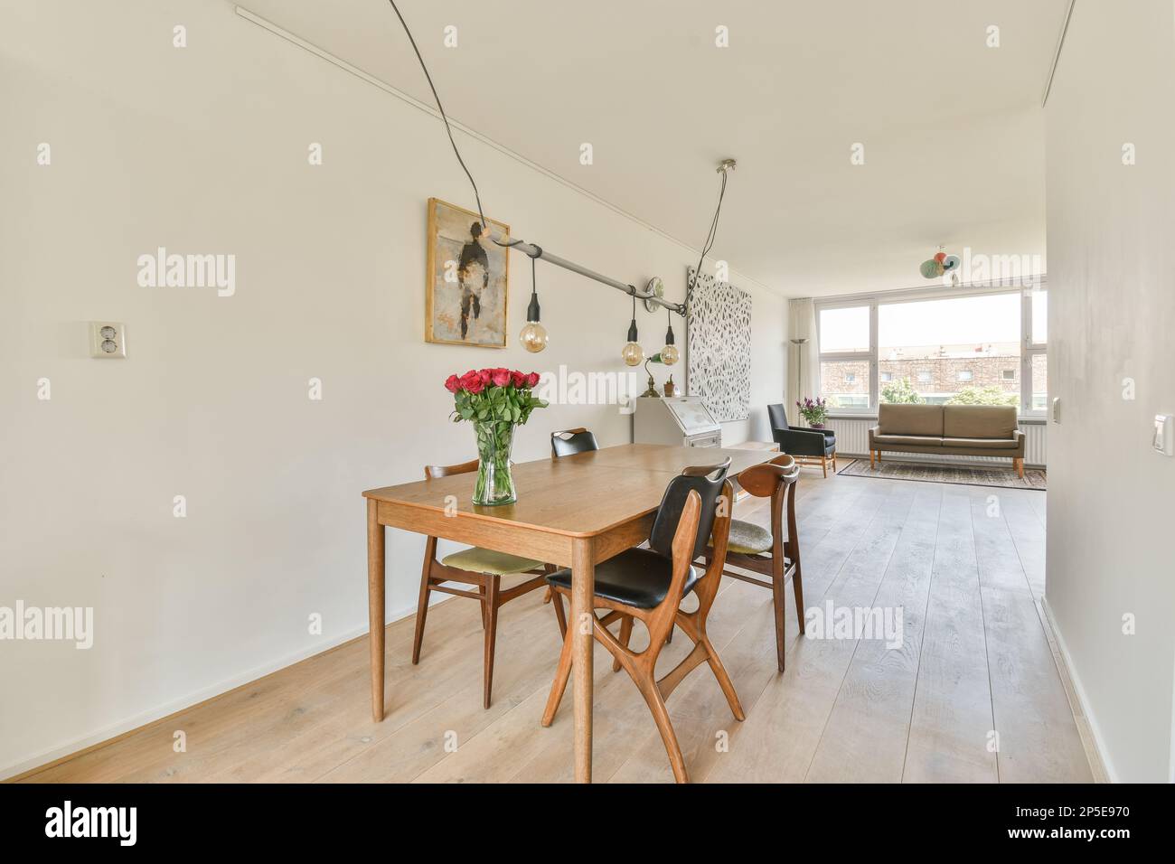 a dining table and chairs in a room with white walls, wood flooring and ...