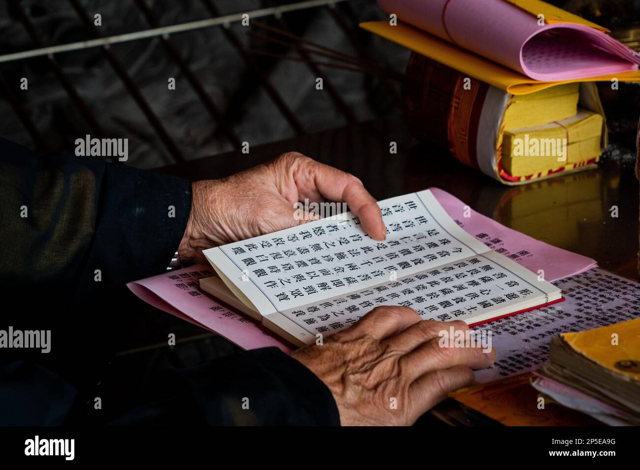 Taipei, Taiwan, 06/03/2023, A Buddhist reads Chinese script during a prayer  ritual at a temple. Daily life in Taipei, the capital city of Taiwan. In a  bid to draw more international tourists,