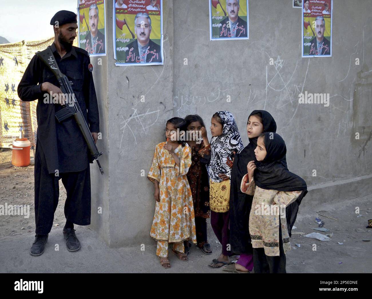 In this Monday, May 6, 2013 photo, Pakistani children look at a soldier
