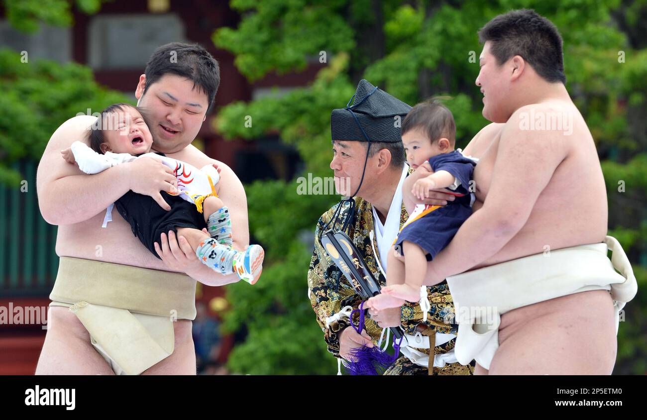 Babies cry in the arms of student sumo wrestlers during the 23rd 