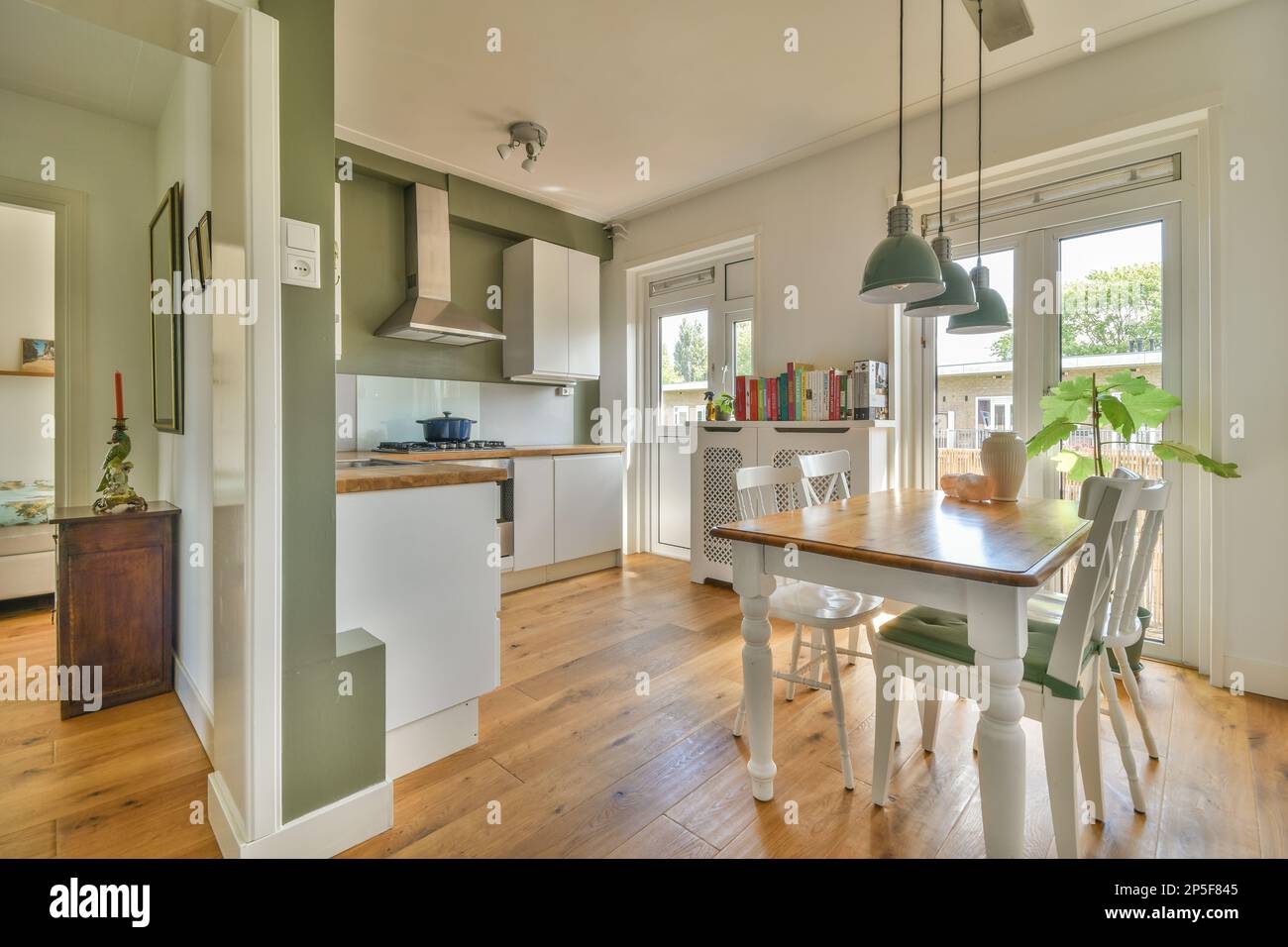 a kitchen and dining area in a house with wood floors, white