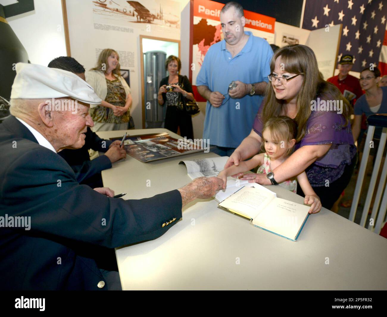 Becky Thatcher, daughter of the late Doolittle Raider Staff Sgt. David  Thatcher, and U.S. Air Force Tech. Sgt. William Hatten from 28th  Maintenance Squadron from Ellsworth Air Force Base, S.D., Ruptured Duck  dedicated crew chief, unveil the newest