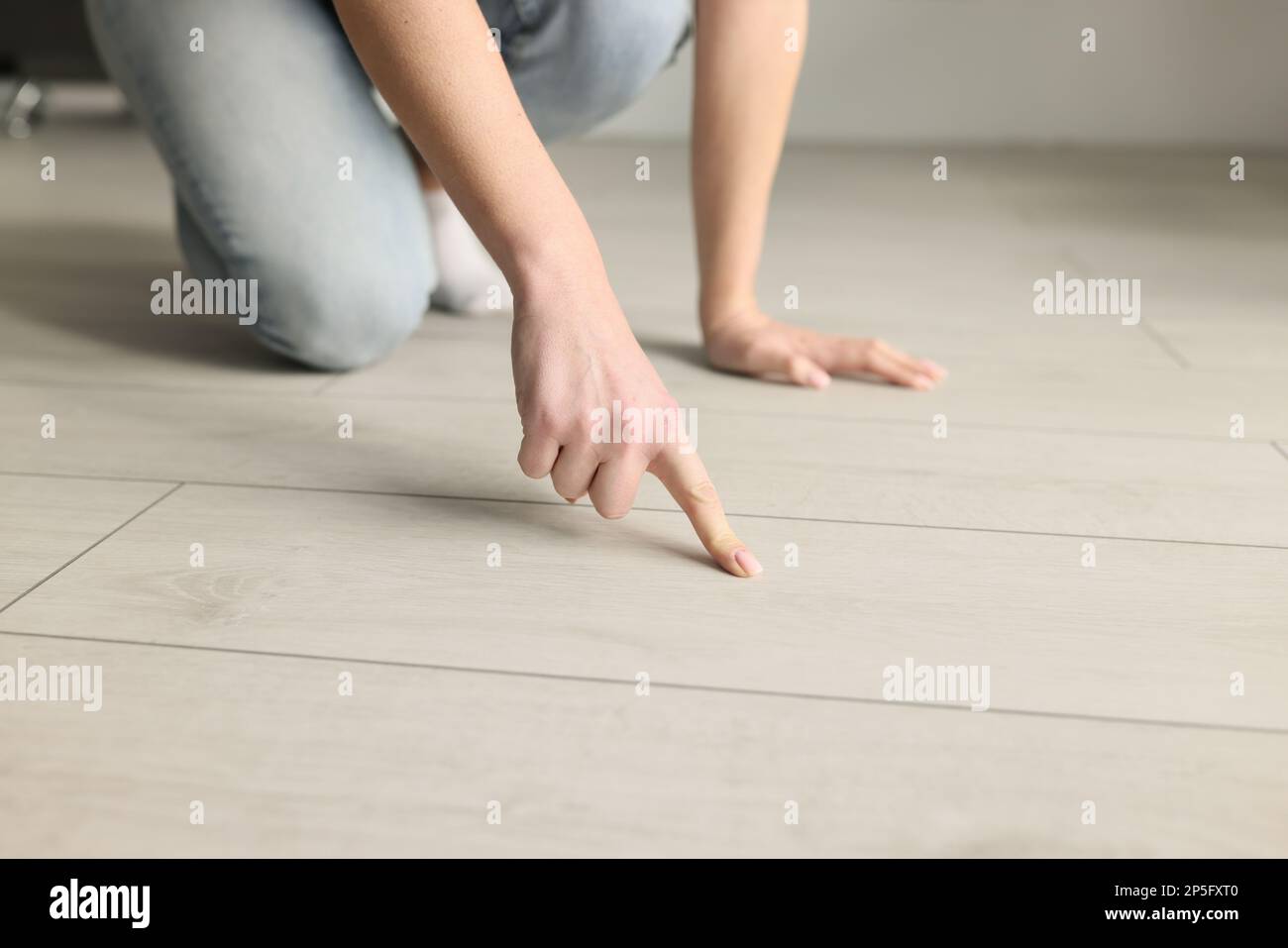 Close-up of woman pointing at wooden floor with her index finger Stock ...