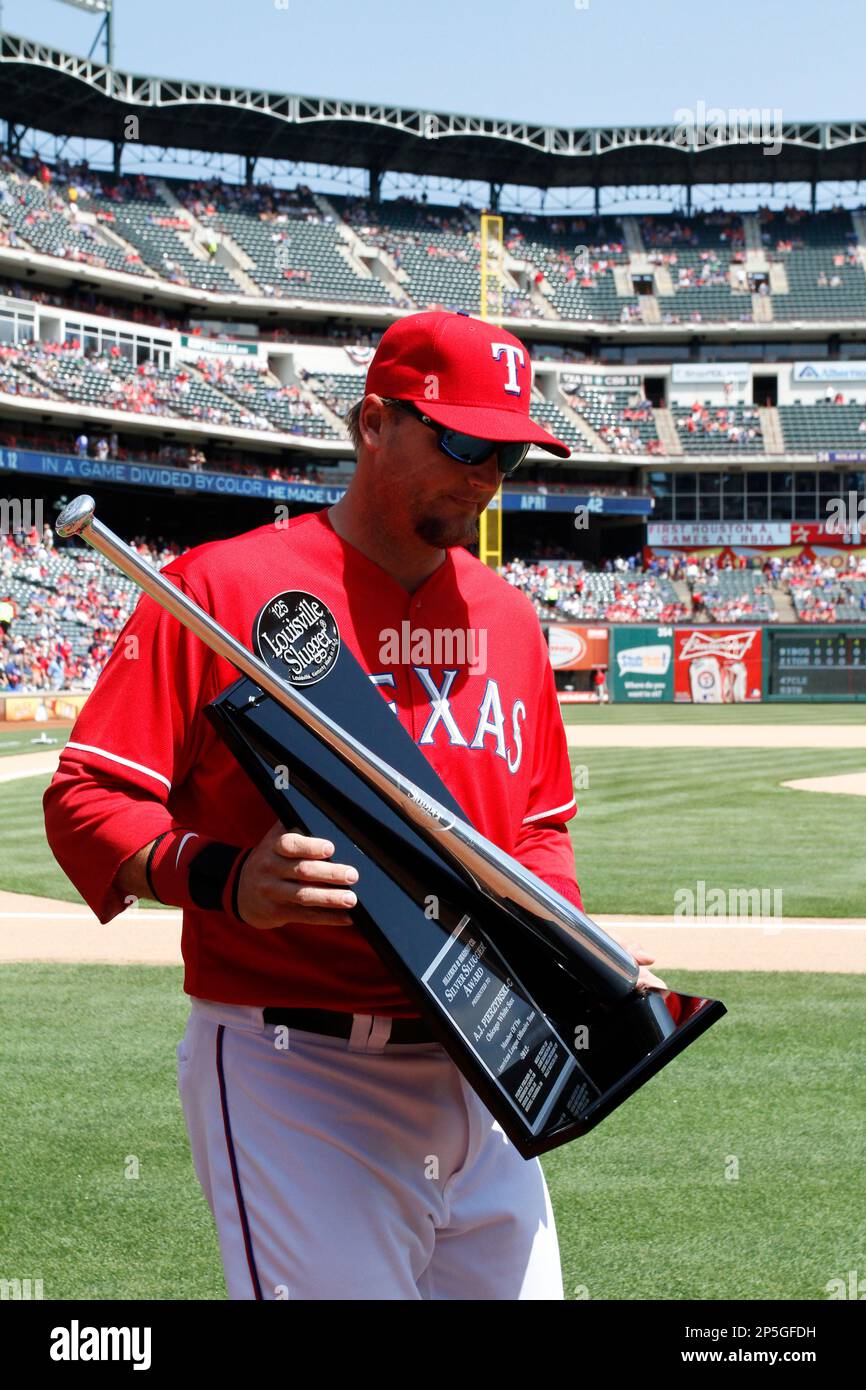 Texas Rangers catcher A.J. Pierzynski leaves the field with the Silver  Slugger Award for his play while on the Chicago White Sox in 2012,  presented before the Rangers' baseball game against the