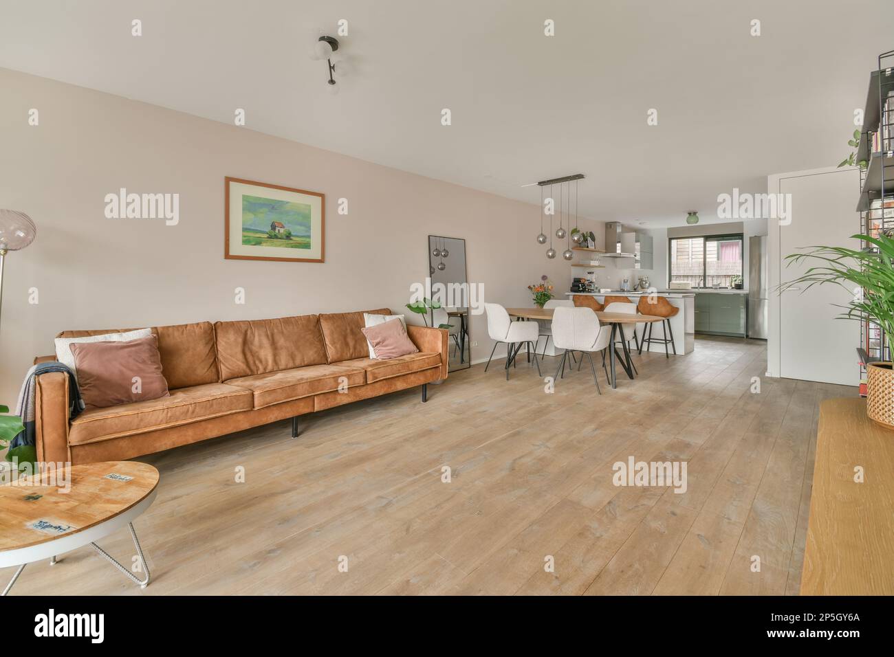 a living room with wood floors and an orange couch in the center of the ...