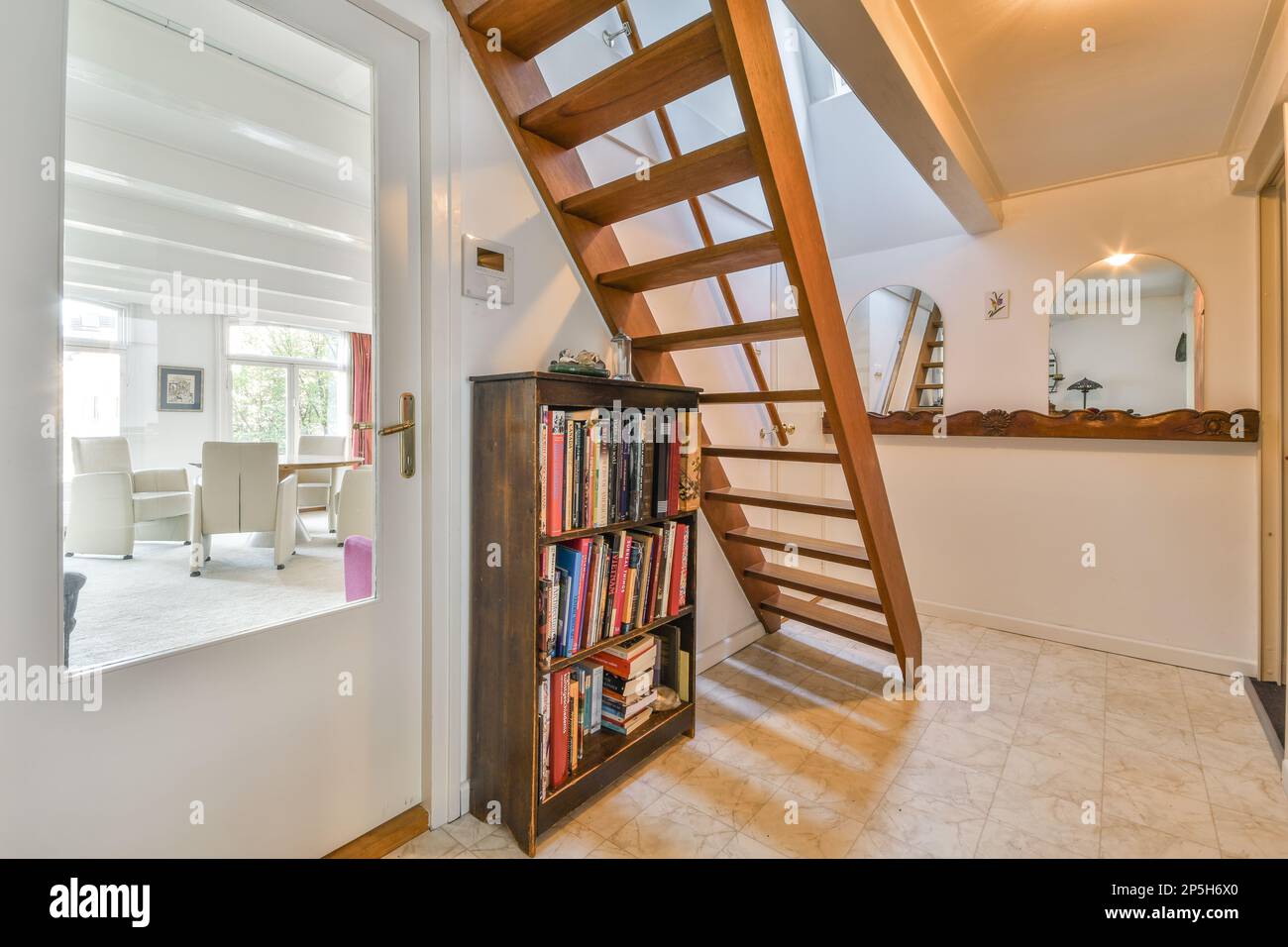 a book shelf in the corner of a room with a staircase leading to an