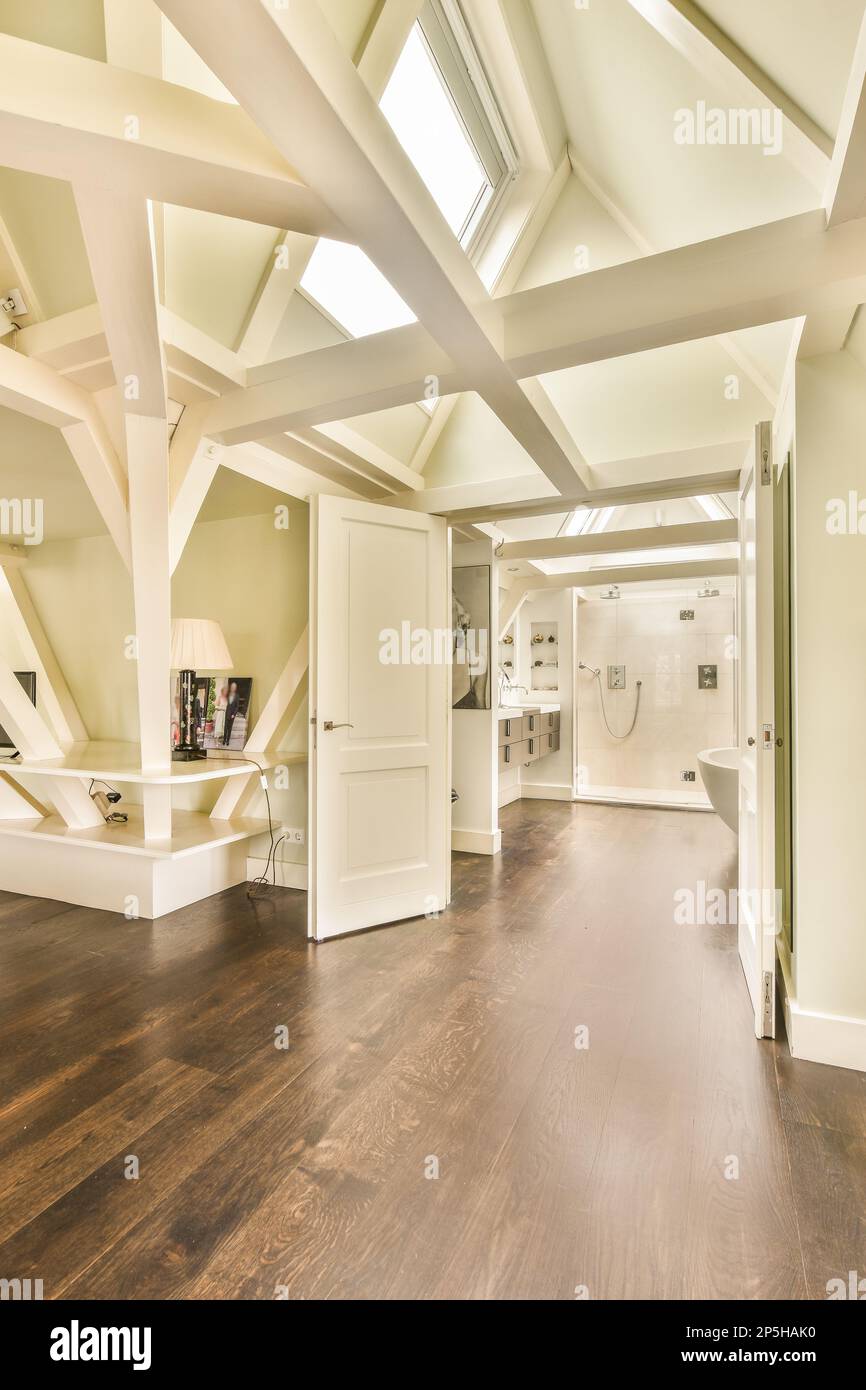 Amsterdam, Netherlands - 10 April, 2021: a living room with wood flooring and white trim on the walls, along an open doorway that leads to another room Stock Photo