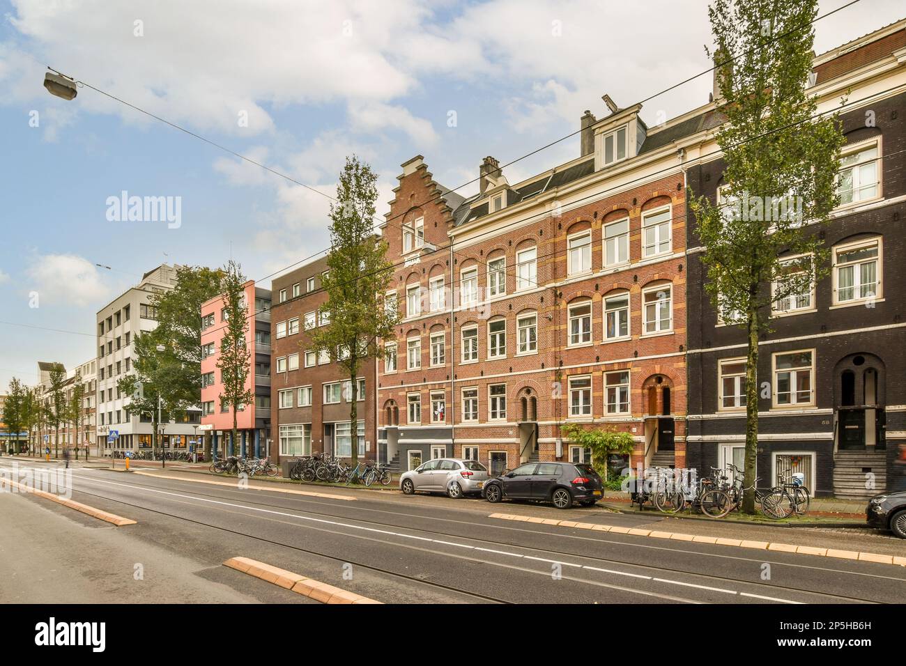 a city street with cars parked on the side and buildings in the middle ...