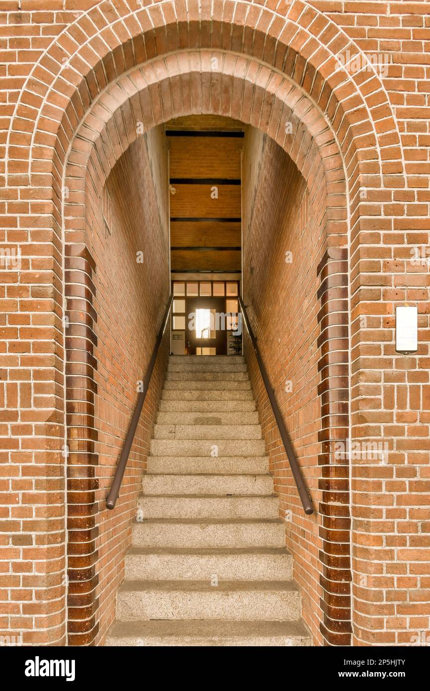 a brick building with stairs leading up to the front door and an open
