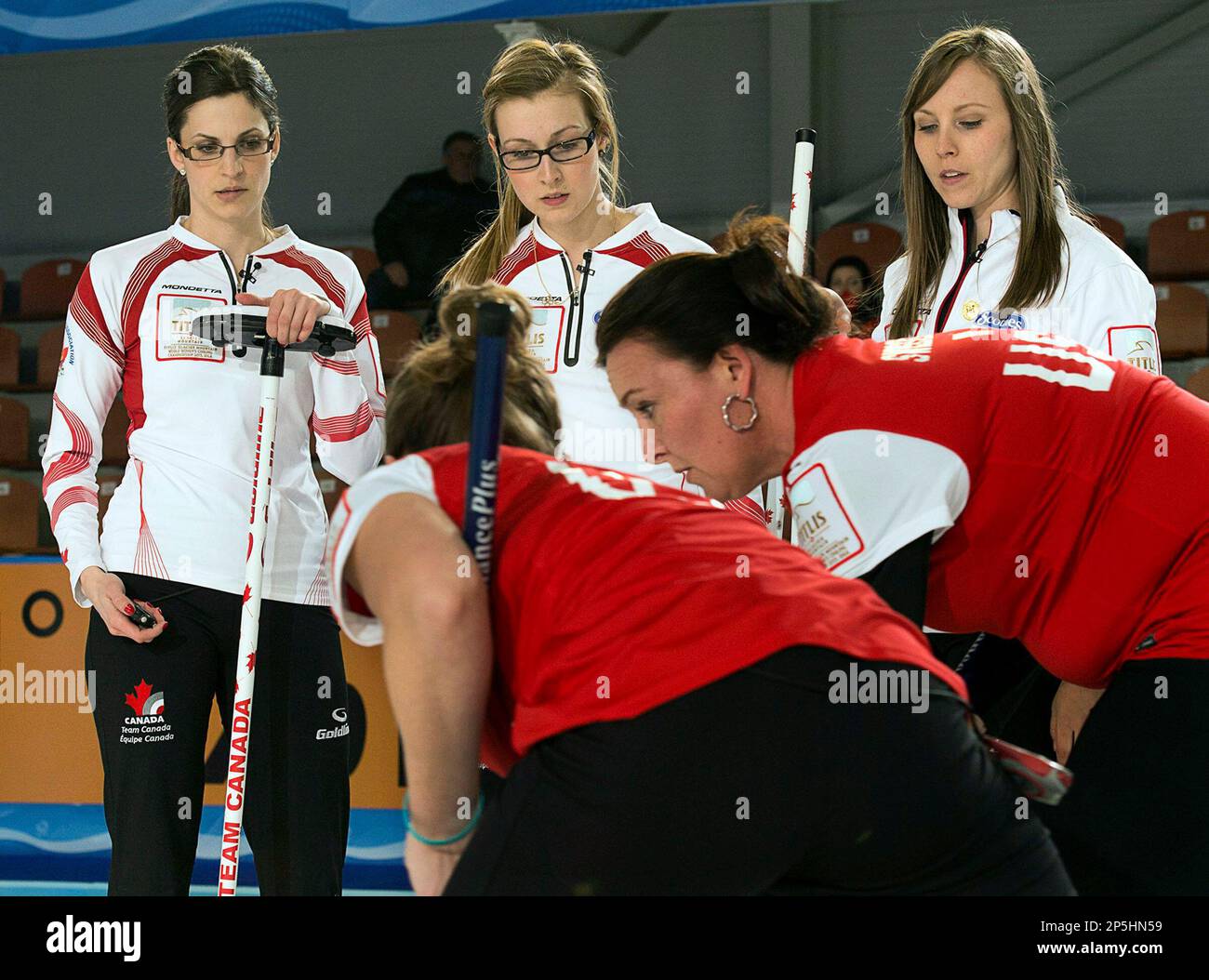 Canadas Lisa Weagle, from left,Alison Kreviazuk and Rachel Homan watch as United States Jessica Schultz and Ann Swisshelm, right, sweep a rock at the world womens curling championship in Riga, Latvia on